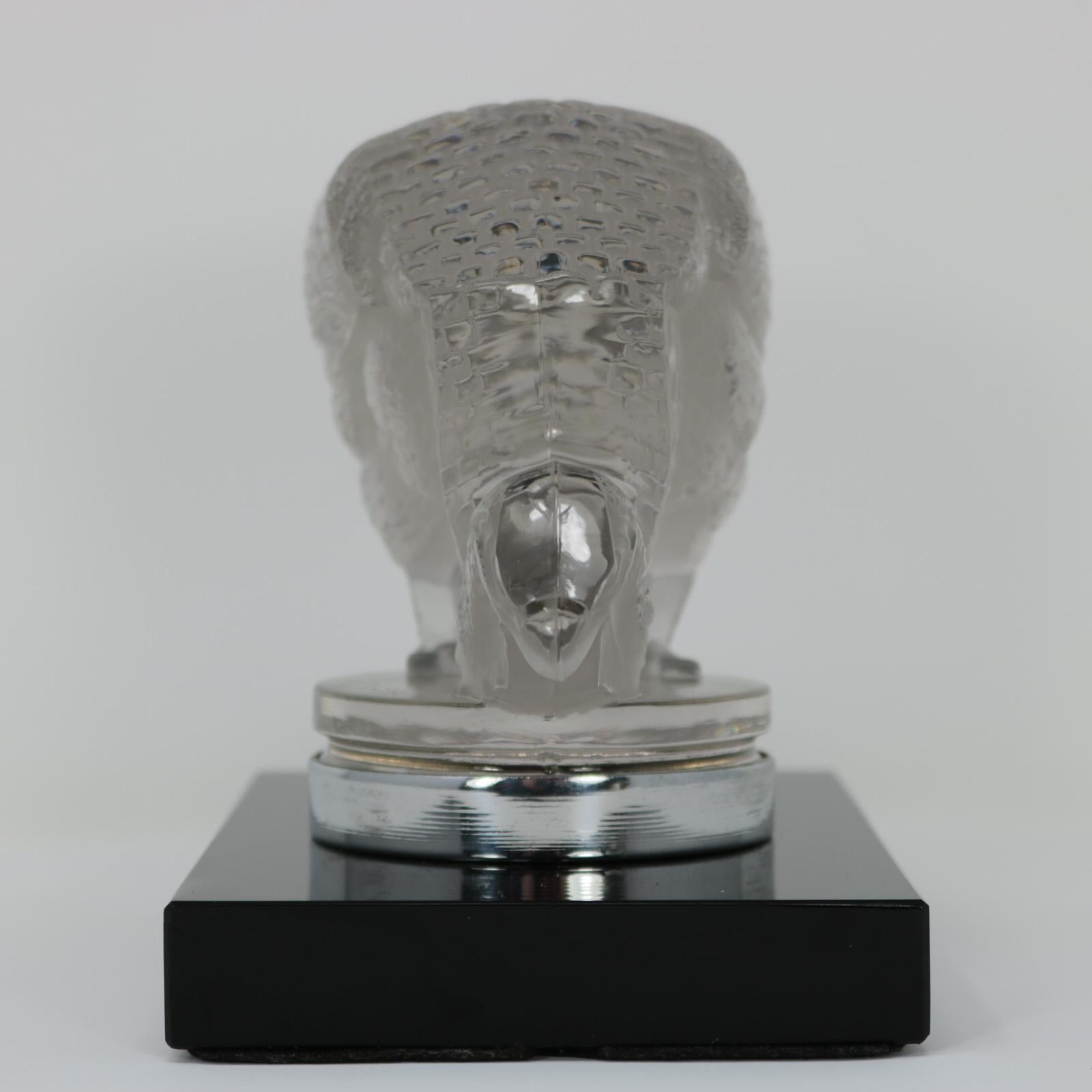 René Lalique clear & frosted glass 'Pintade' car mascot. This model features a grazing guinea fowl bird. The bird is mounted onto a rectangular, black glass base. Moulded maker's mark in front of bird's right foot, 'R LALIQUE' and 'FRANCE' on