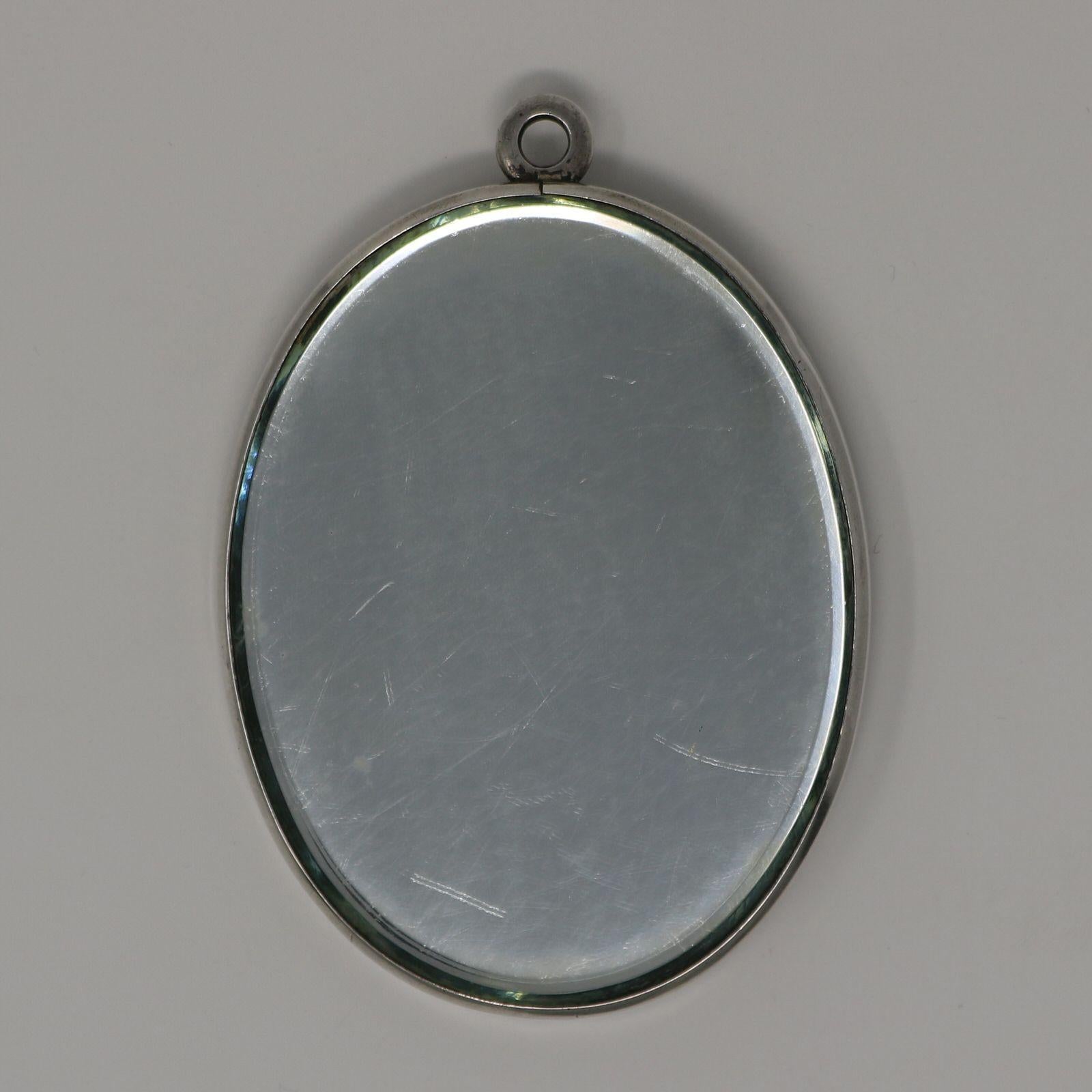 Miroir 'Psyché' en verre clair et dépoli de René Lalique. L'une des faces de cette pièce comporte un miroir, l'autre une tablette en verre moulé. Tous deux sont placés dans un cadre métallique. Ce motif représente une femme nue et ailée. Elle