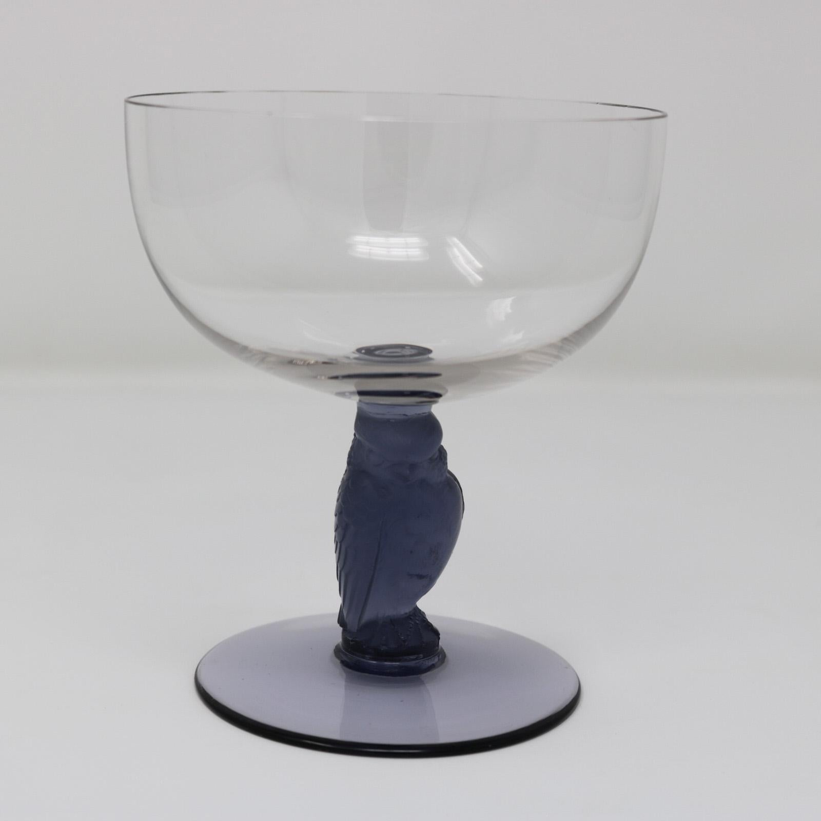Rene Lalique glass 'Rapace' champagne drinking glass. Clear glass bowl and foot. Blue glass stem modelled in the form of a raptor bird (by direct translation of rapace). Engraved makers mark, 'R Lalique France'. Book reference: Marcilhac page 805,