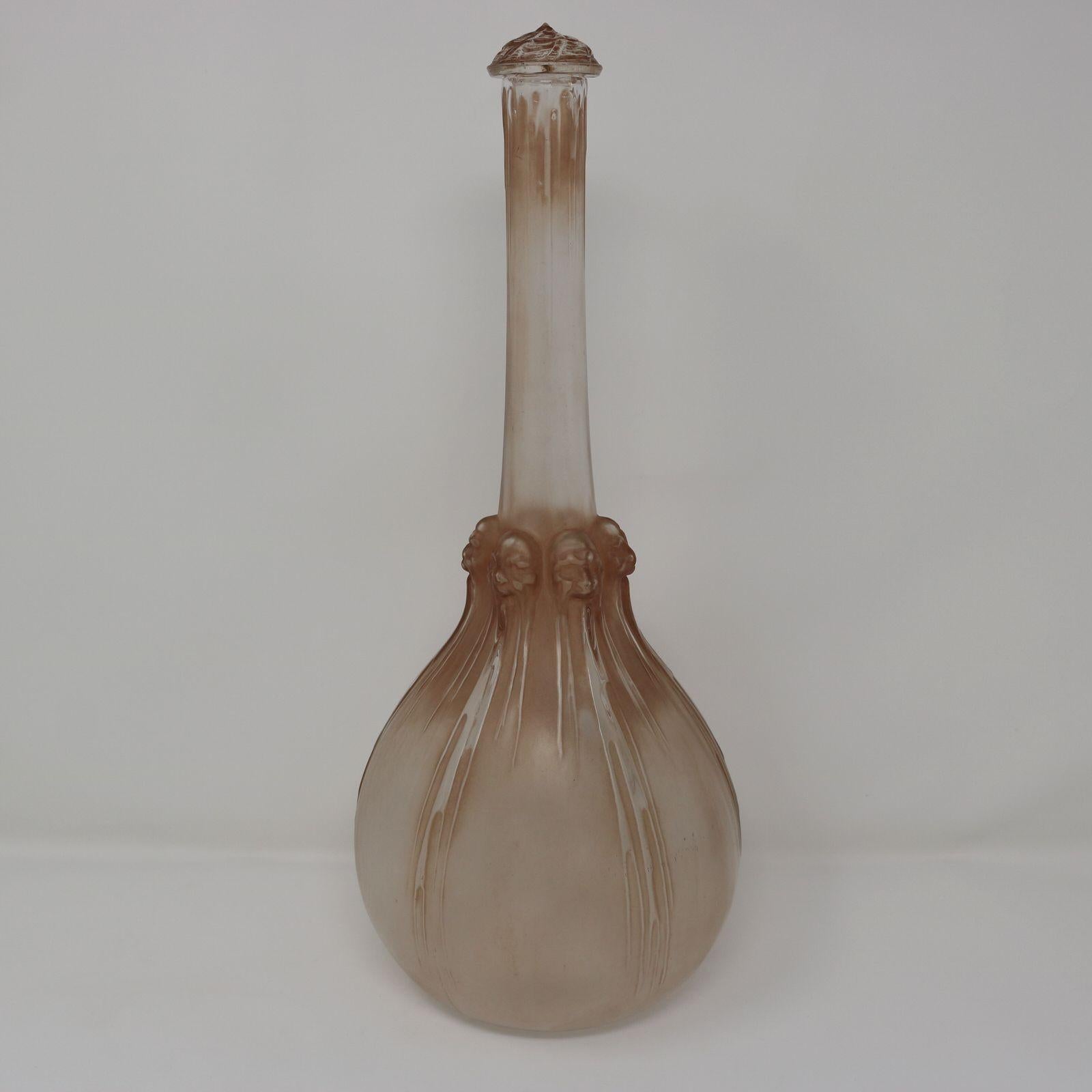 Rene Lalique Karaffe Six Tetes aus klarem und mattiertem Glas. Dieses Muster zeigt sechs Köpfe um den Hals. Jeder hat einen anderen Ausdruck. Von jedem Kopf läuft ein klares Glasmuster herunter, das vielleicht einen Bart und Haare darstellt. Der