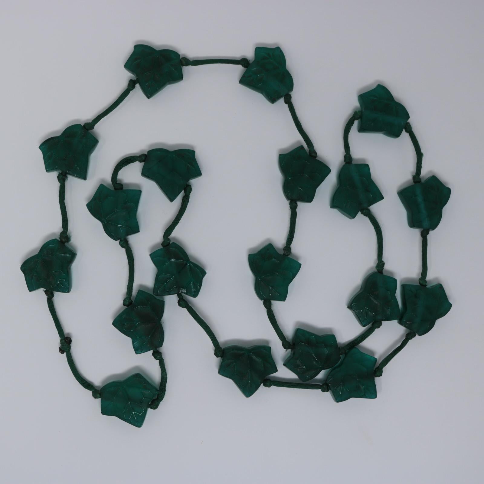 Rene Lalique green glass 'Feuilles De Lierre' leaves necklace. Necklace features 19 green glass ivy leaves, strung onto a silk cord. Book reference: Marcilhac 1505. Dimensions given are for each leaf. The total length of the necklace is 95cm
