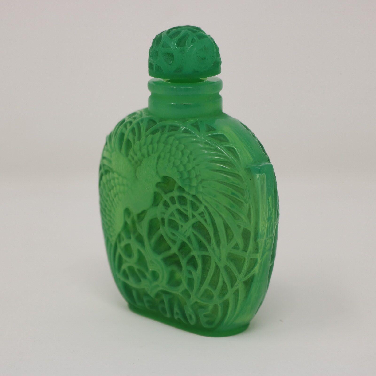 Rene Lalique green glass perfume bottle. Made for Roger & Gallet of Paris for 'Le Jade' perfume. Pattern features a tropical bird (cockatoo) amongst foliage. Moulded makers mark, 'R L FRANCE' to the underside. 'ROGER ET GALLE PARIS' to one side and