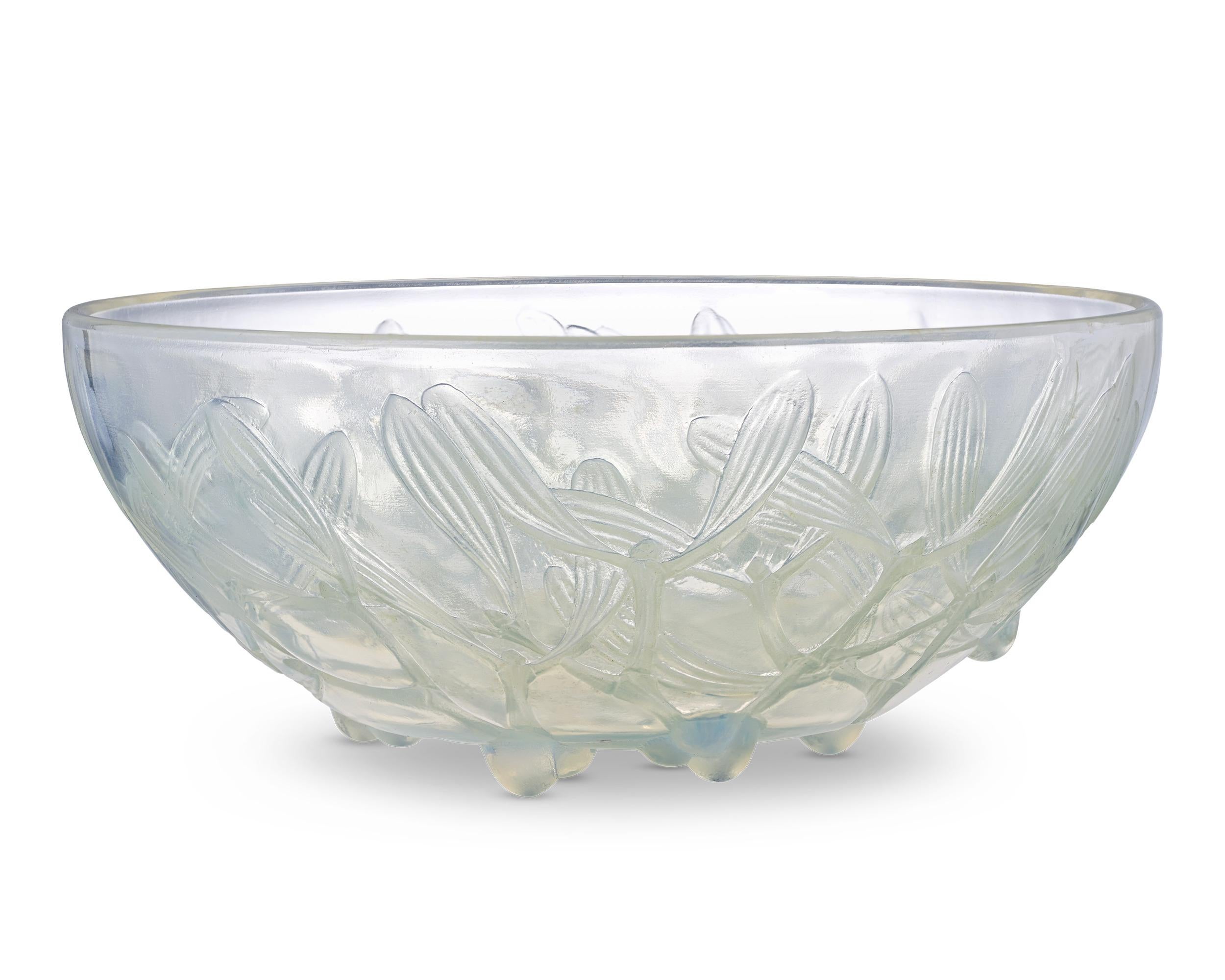 Zarte Mistelfrüchte schmücken diese auffällige Schale aus opalisierendem Glas des berühmten René Lalique. Das 1920 erstmals von Lalique entworfene Gui-Muster ist in Flachrelief gegossen und zeichnet sich durch exquisite Details aus. Diese Schale ist