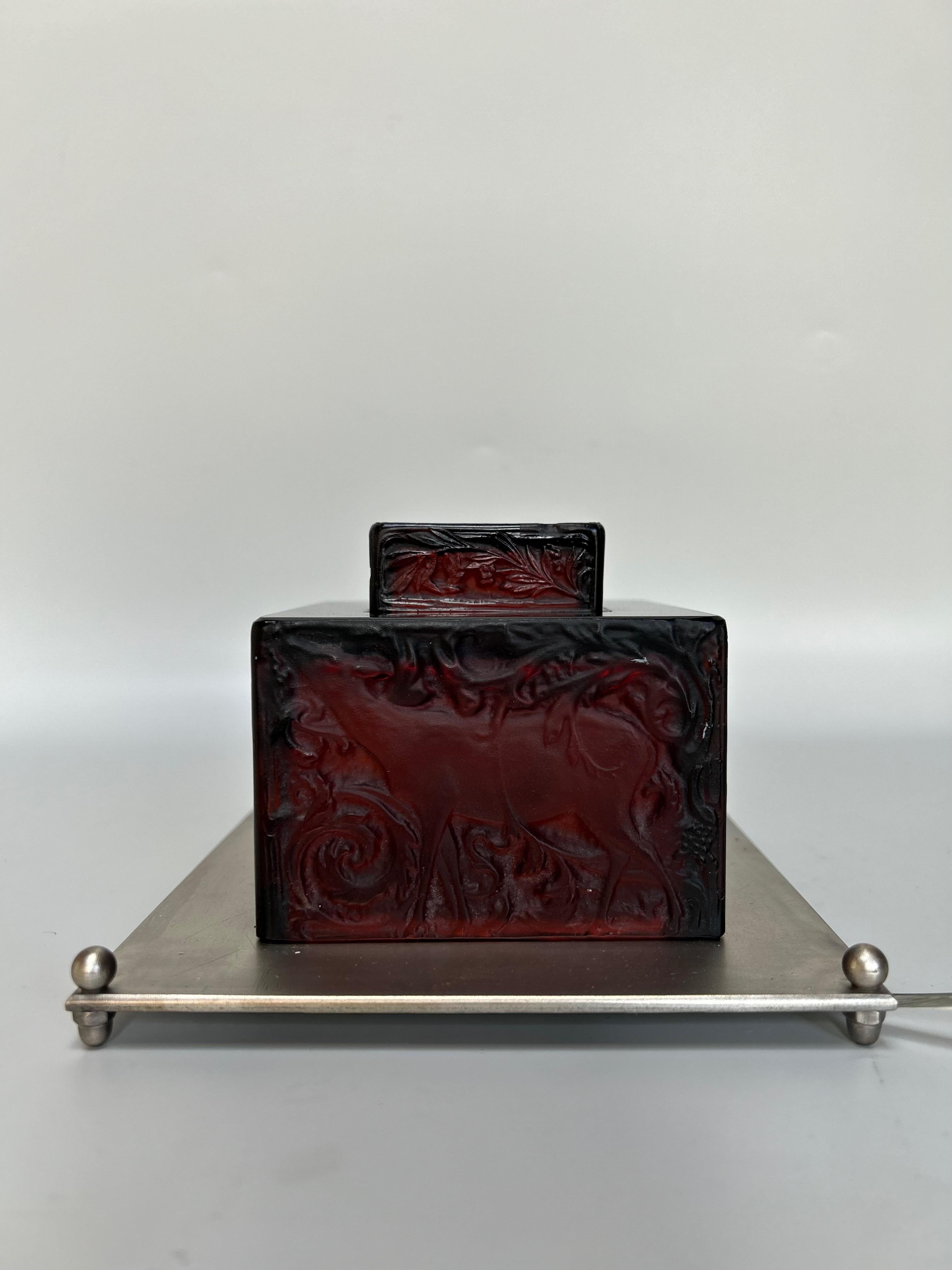 Luce notturna a calamaio di René Lalique, in vetro stampato rosso scuro. 
Base in bronzo argentato.
Elettrificato. 3 schegge lucide.
Altezza totale: 10 cm
Larghezza: 15 cm
Profondità: 15 cm 

Nato nel 1860 ad Aÿ in Champagne, René Lalique si è