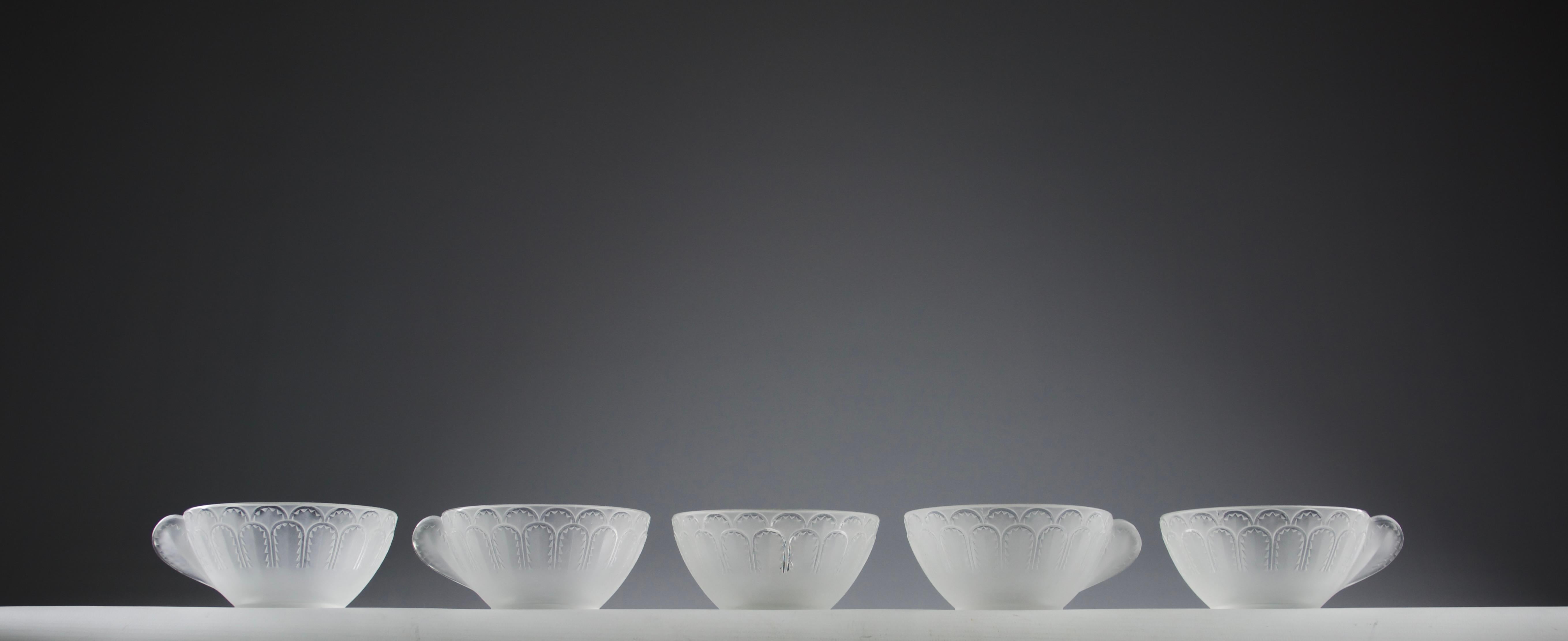Magnifique service à thé/café 'Jaffa', modèle créé par René Lalique en 1931. Signé R. Lalique.

En bon état. Légers signes d'utilisation, une tasse avec deux éclats plats et des grenures sur la base.

Dimensions en cm ( H x L x l ) : 4,8 x 11,5 x