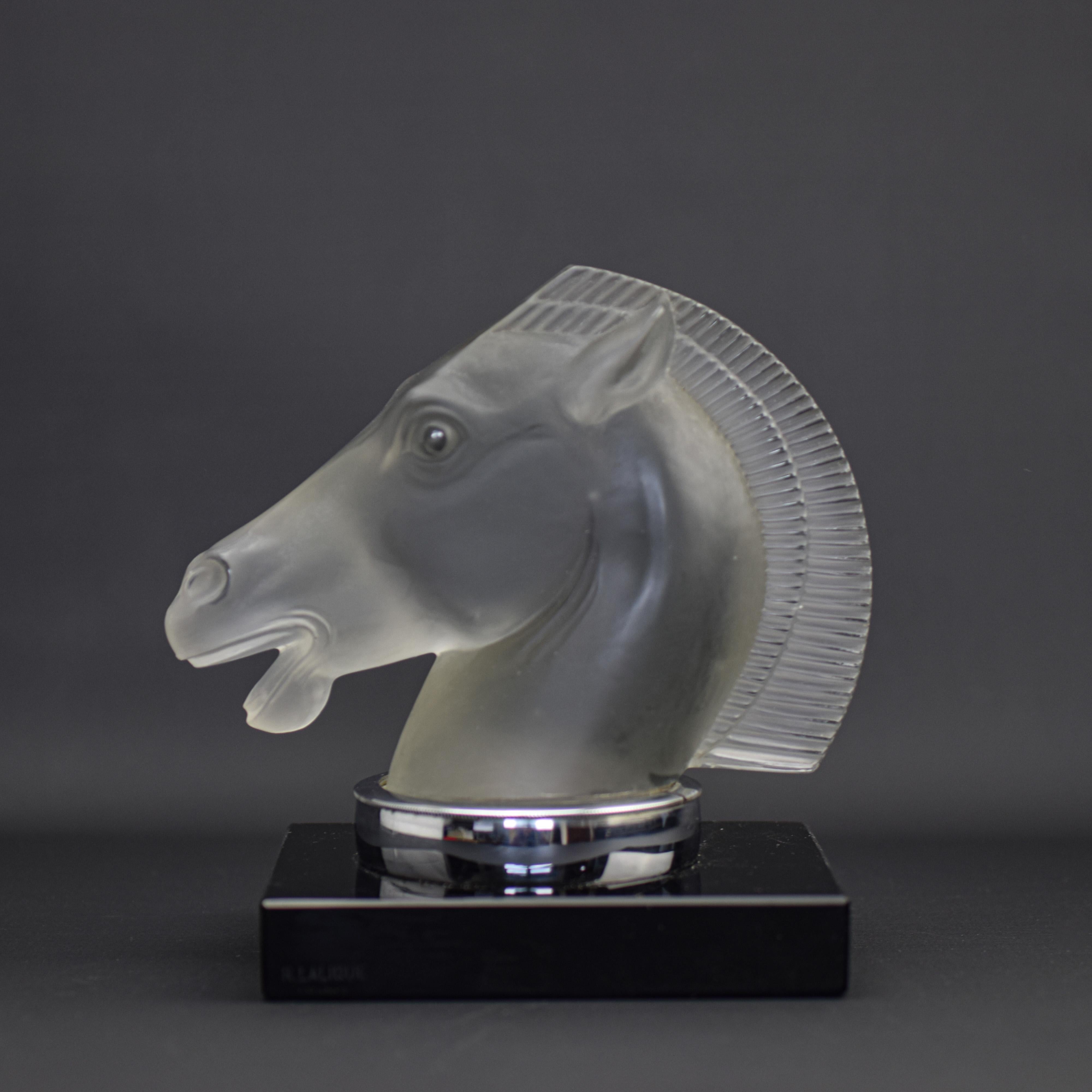 Hard to find Rene Lalique Longchamp A double mane car mascot. The condition is very good with no damage or faults. There are some typical air bubbles present within the glass. A fine groove was ground around the base to allow the chrome mount to be