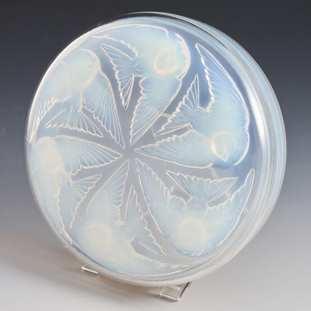 A René Lalique Two-Part mesanges box designed in 1921 in Wingen-sur-Moder, France. The bowl features opalescent blue and pale yellow; impressed with six birds in flight. Moulded R.LALIQUE signature

René Jules Lalique is unequivocally one of the