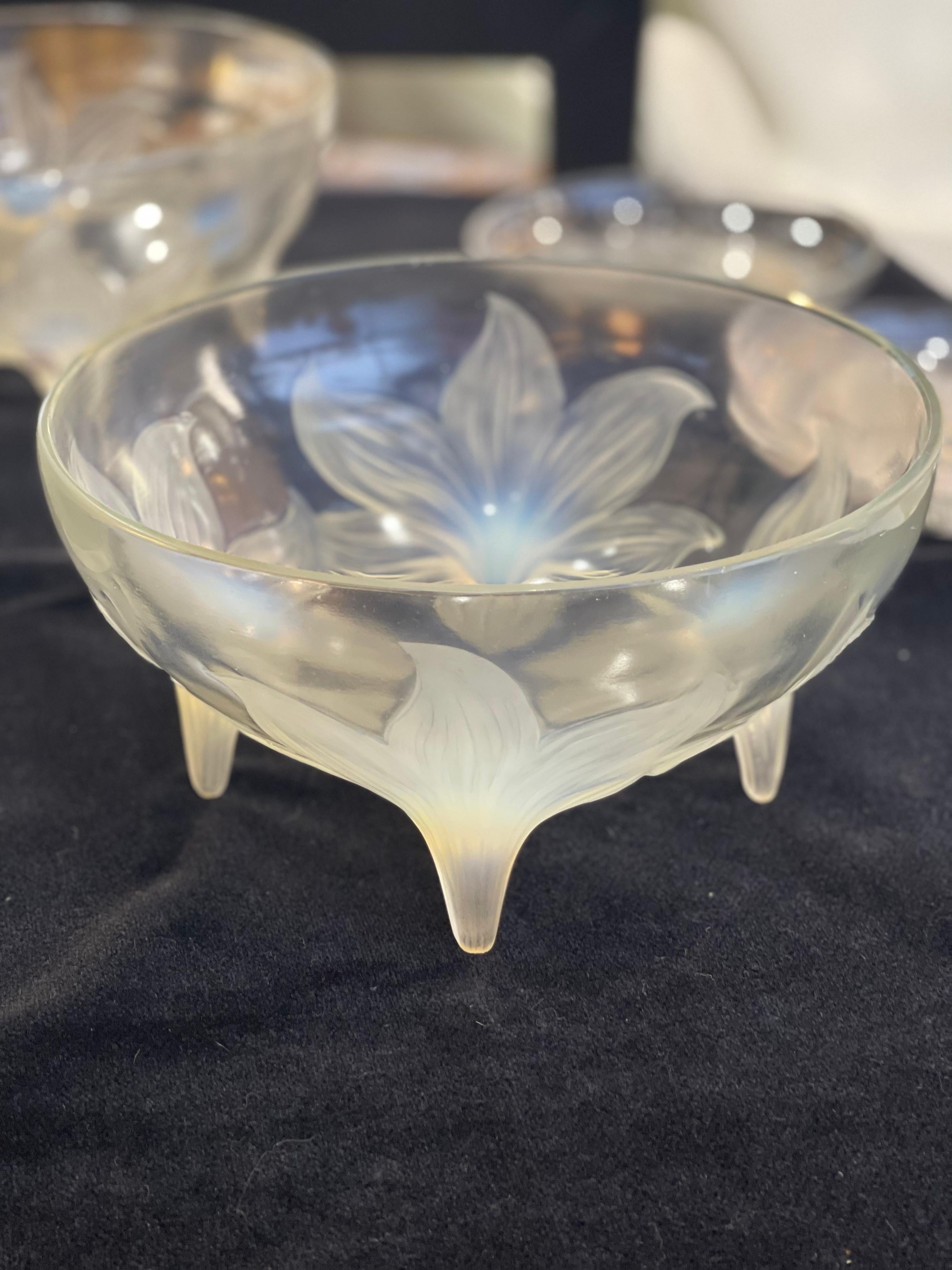 Rene Lalique bowl Lys: 9 and 1/4 inch four flower motif resting on the four stems round molded opalescent glass 
Bibliography : N° 382 du catalogue Marcilhac
Model: 382 Circa 1924
Diameter : 23,7 cm
Height : 13 cm.