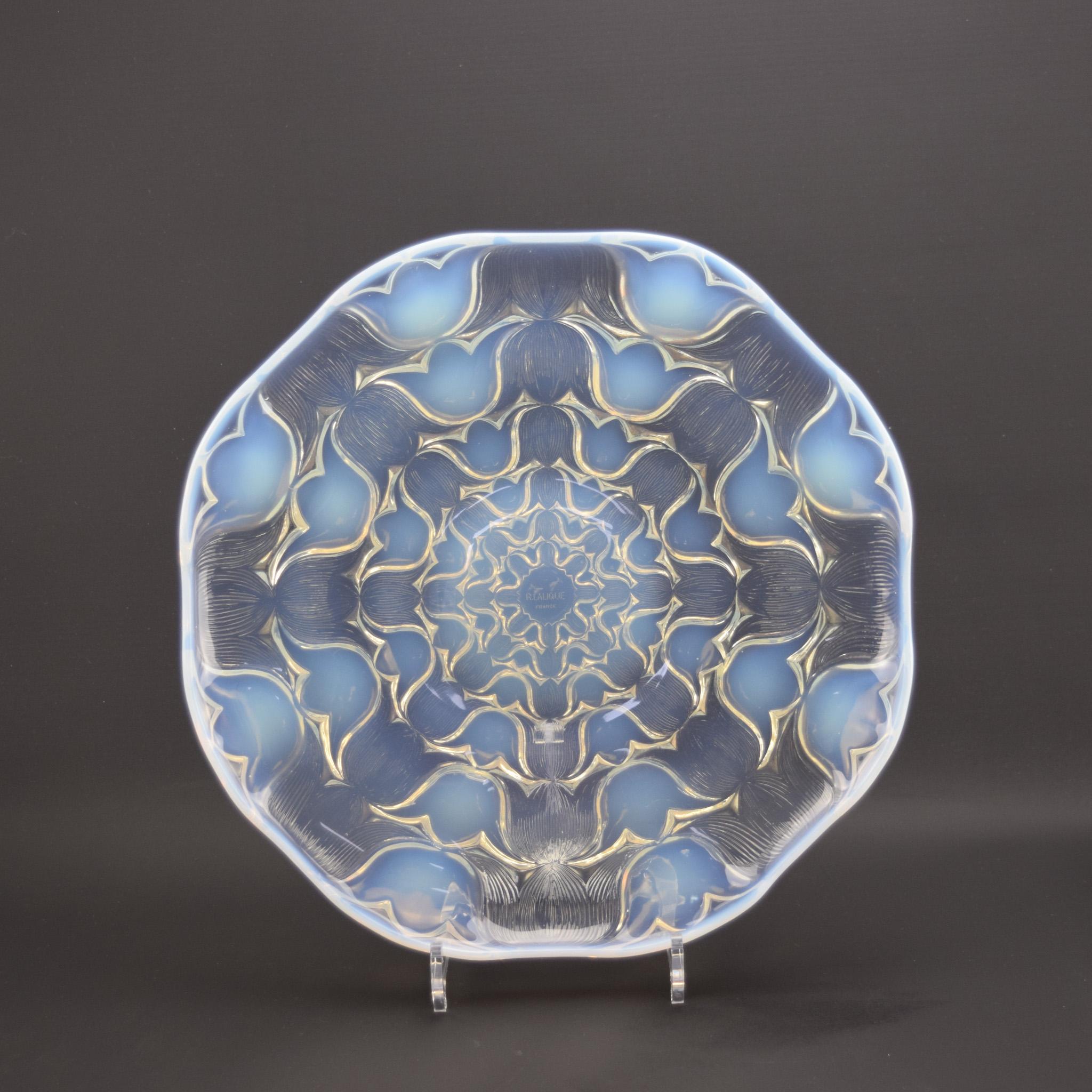 Piatto coupe Campanules oplaescente di Rene Lalique.
Un esempio estremamente bello con un'incantevole opalescenza con un disegno ripetuto di teste di campanule che passano dall'opalescenza alla trasparenza.
Le condizioni sono molto buone, senza