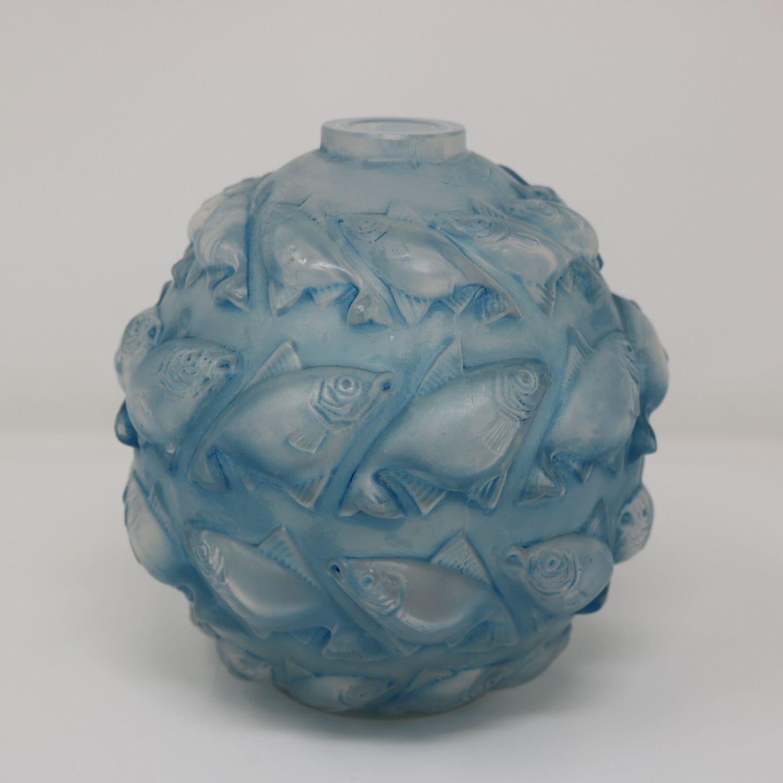Rene Lalique Opalescent Glass with blue staining, 'Camaret' Vase. This pattern features four rows of fish molded in relief. Engraved makers marks, 'R Lalique France No.1010'. Book reference: 'R. LALIQUE Catalogue Raisonne De L'Oeuvre De Verre', by
