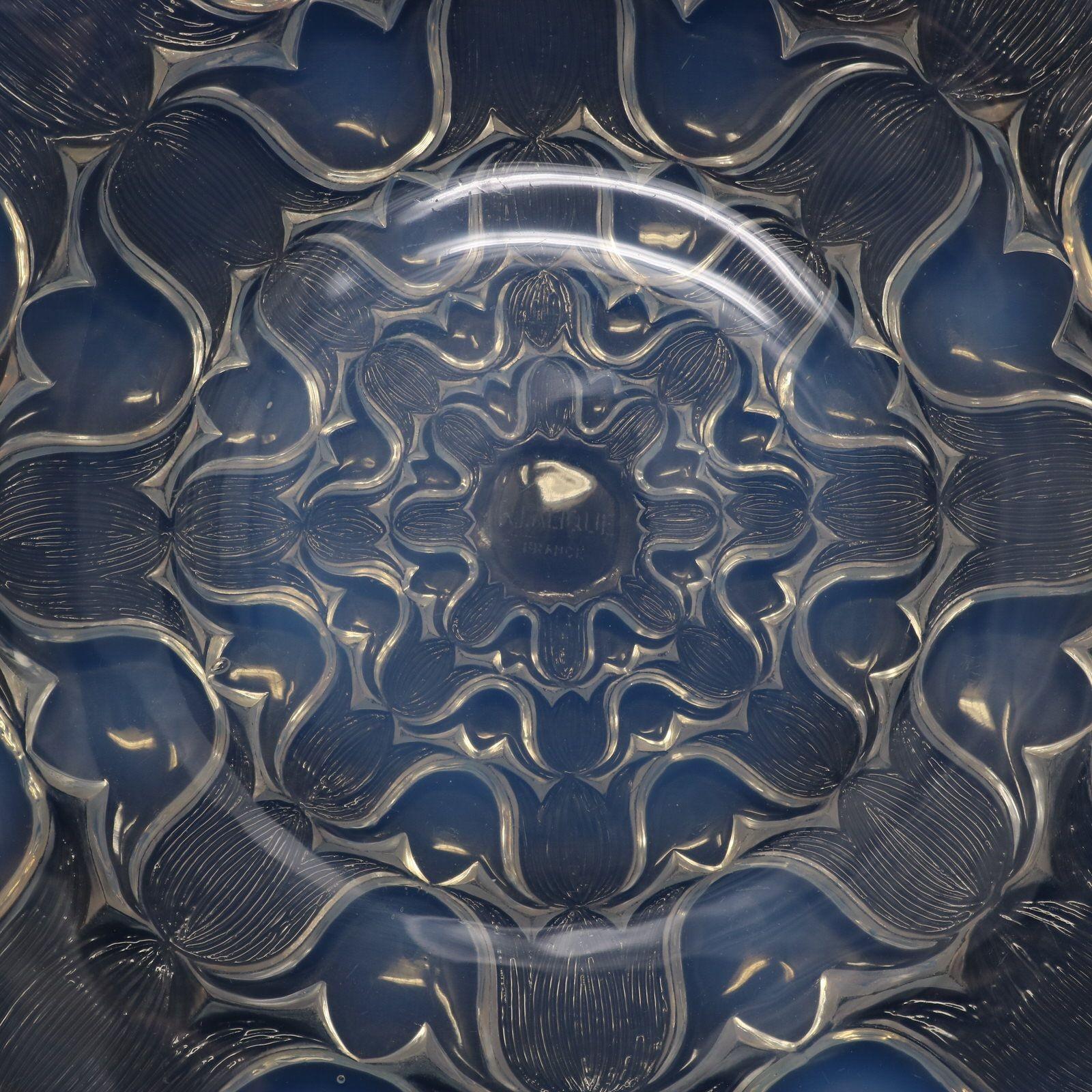 Assiette Campanules en verre opalescent de Rene Lalique. Ce modèle présente un motif répétitif de fleurs de bleuets. La forme est celle d'une 