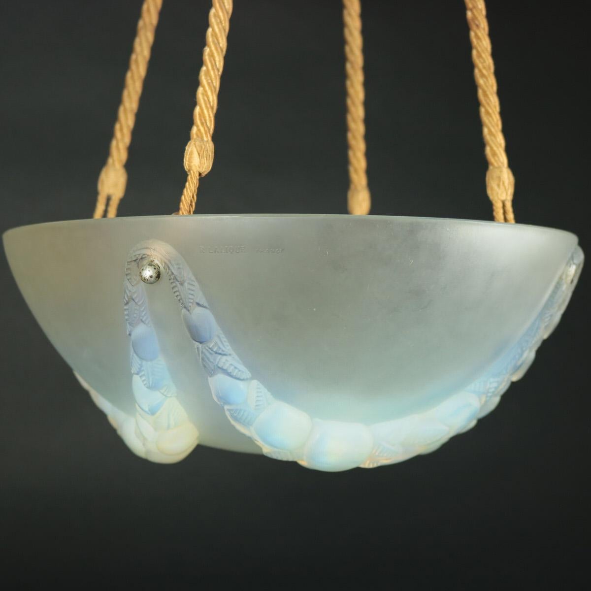 René Lalique opalescent and frosted glass Villeneuve ceiling light shade. This pattern features hanging garlands of fruit and leaves, around the outside. Four hooks bolted around the sides (removable), which attach the rope for hanging the shade.