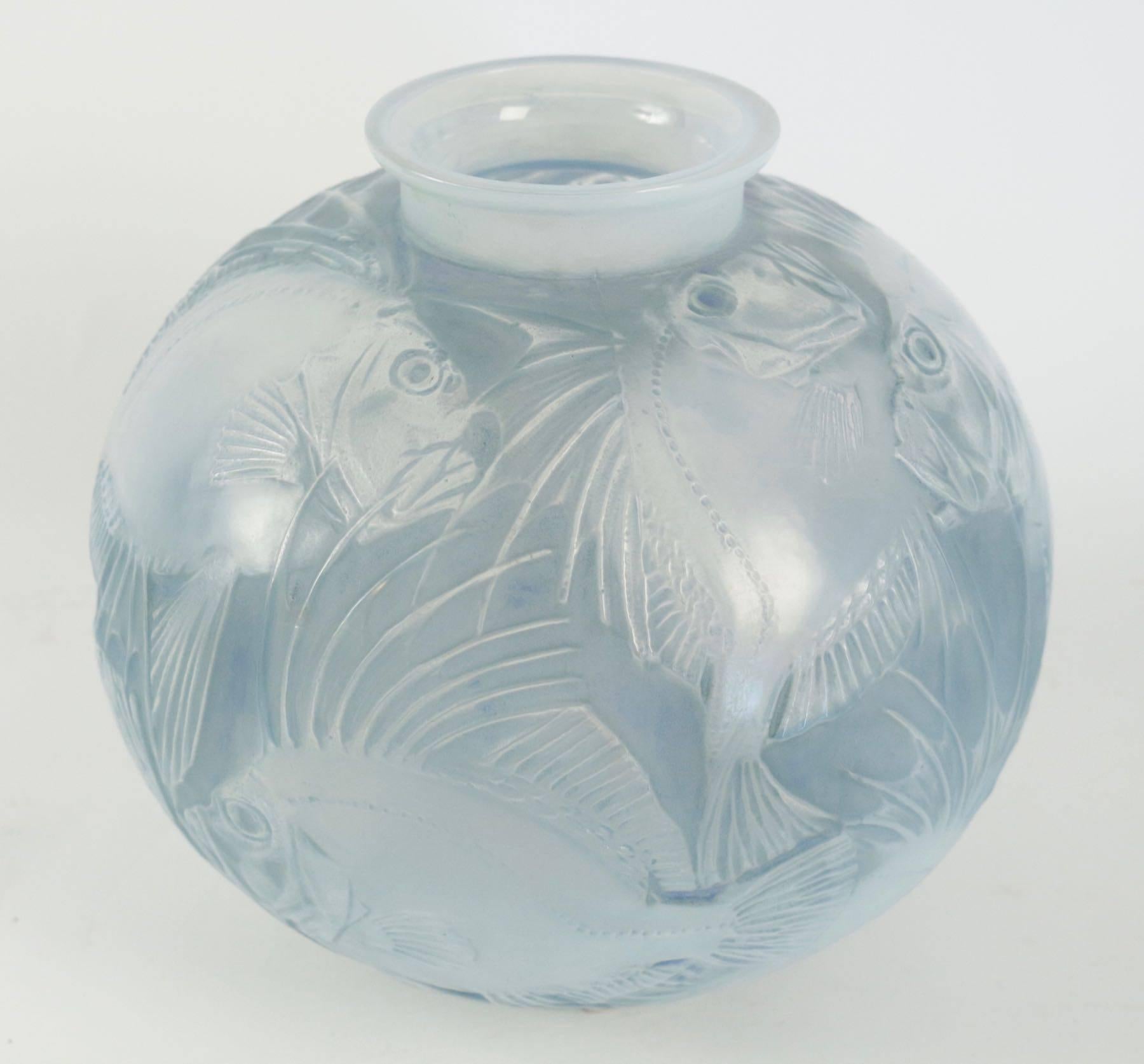 René Lalique (1860-1945) vase Poissons created in 1921.
Stopped in 1937.
Measuring 24.5 cm tall opalescent glass and highlighted with blue stain fish decorated glass R. Lalique Vase with both a relief molded signature on the side of the