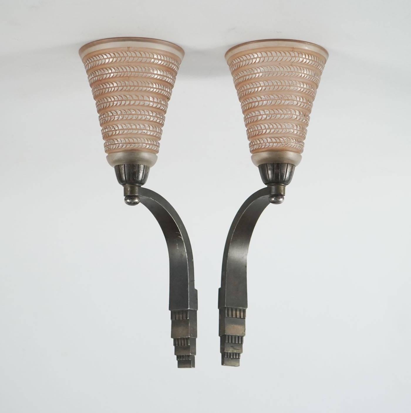 Frosted and highlighted with sienna patinated stain glass with a bronze applique mount; Art Deco stylized vertical bands of small leaves on stems tulipe
Model: 2702, circa 1926.
Paire d'appliques à deux tulipes en verre moulé pressé modèle