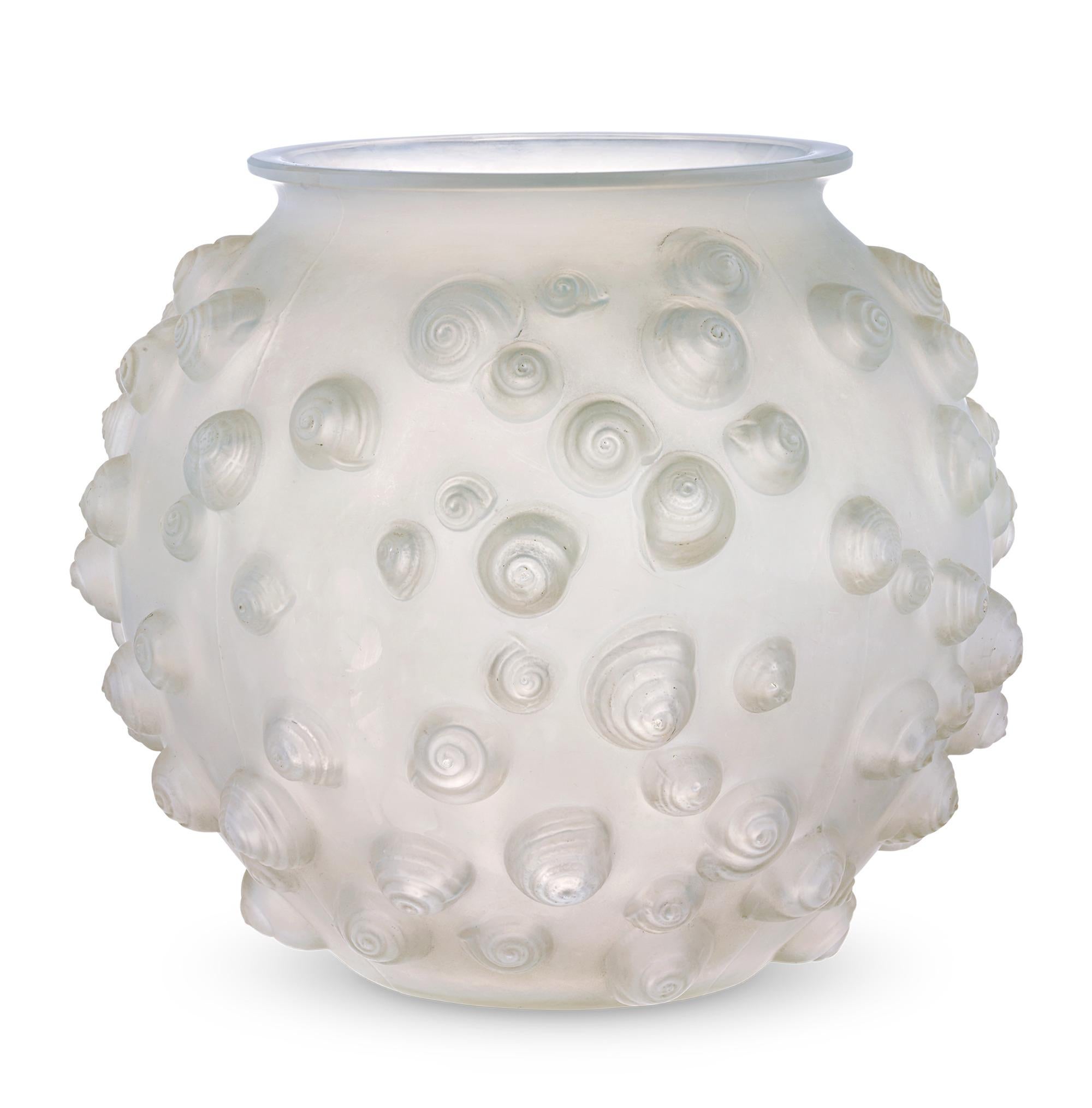 Disegnato da René Lalique il 12 novembre 1926, questo vaso con motivo Palissy è caratterizzato da bellissime conchiglie coniche che sporgono dalla forma del vaso. Il vaso evidenzia l'amore del maestro per le forme audaci e i motivi naturali che