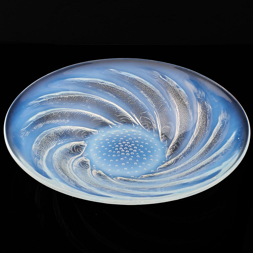 Poissons No.1 Coupe Ouverte an Art Deco opalescent and frosted glass shallow bowl by René Lalique with swirling fish surrounded this centre.

René Jules Lalique (French, 1860–1945) was a renowned jeweller and master glassmaker. As one of the