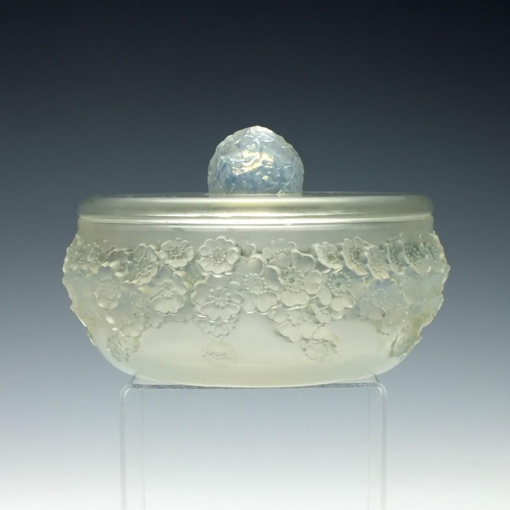 Rene Lalique primeveres box and cover no 77

Moulded flowers below a plain top with a floral finial

Designed 1927.

      