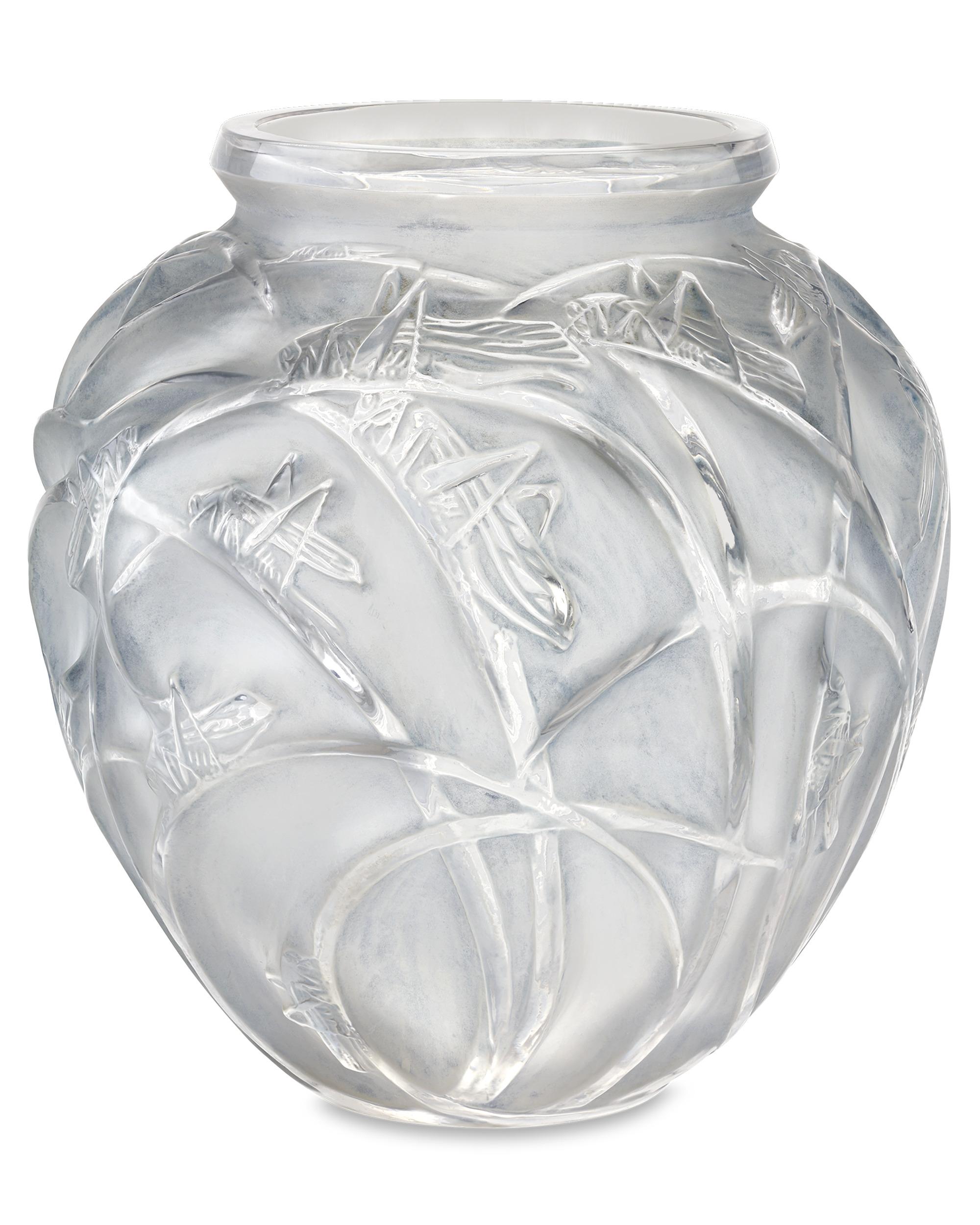 Diseñado por René Lalique en 1912, este jarrón con motivos Sauterelles presenta detalles de caprichosos saltamontes descansando sobre largos juncos o briznas de hierba. La vasija pone de relieve el amor del maestro por las formas atrevidas y los