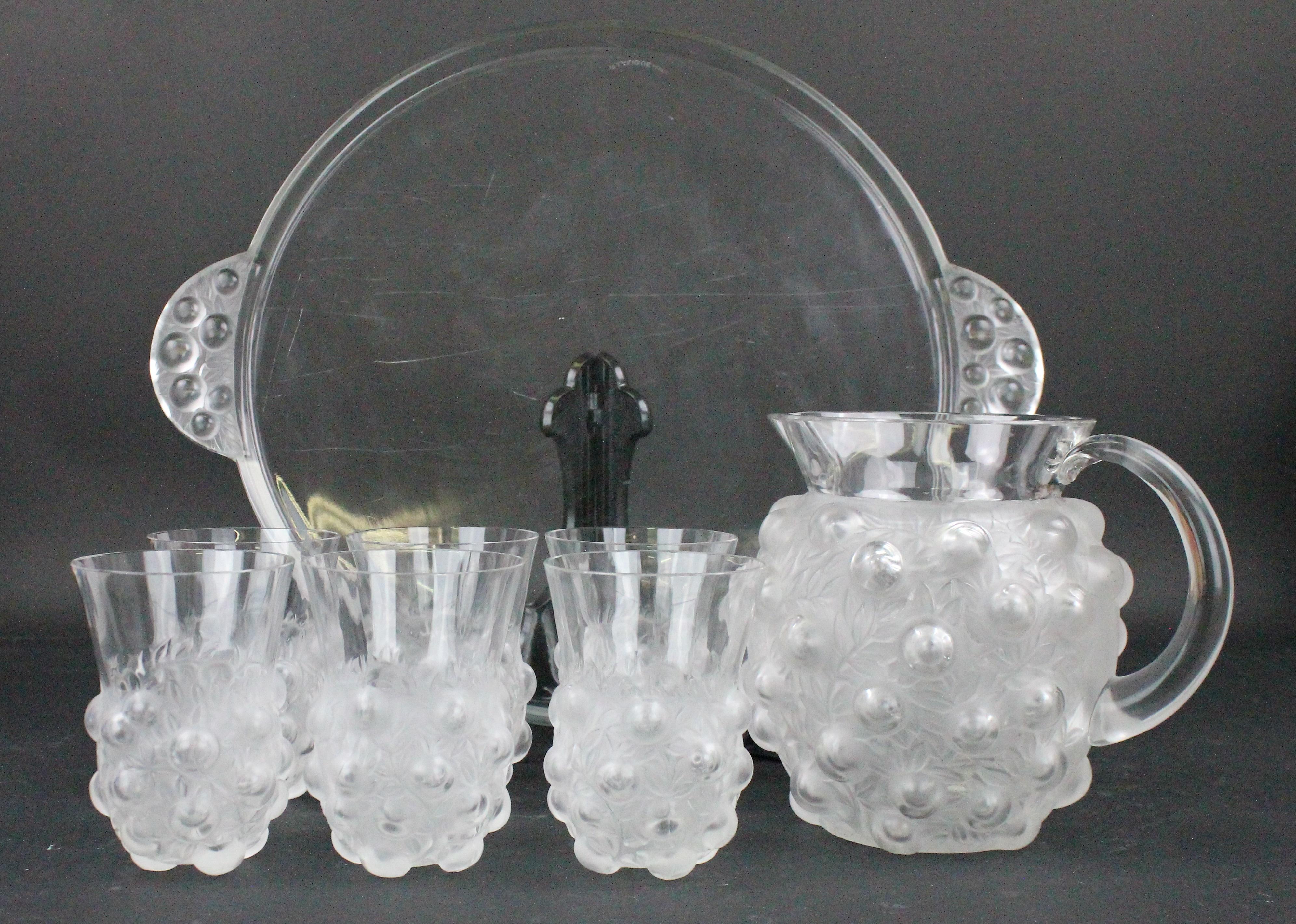 Eight-piece lemonade set by René Lalique. One tray, one pitcher and six glasses. All eight pieces in perfect condition (some minor scratches underneath). There are no damages or nicks. This model has not been manufactured by Lalique after 1947. All