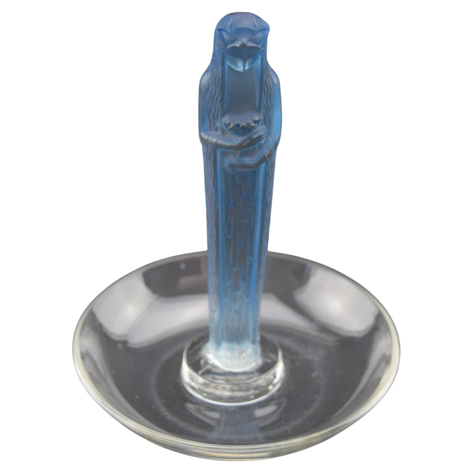 Cenicero René Lalique fuente de la Fontaine. Vidrio transparente y esmerilado realzado con manchas azules
Grabado R Lalique junto con el número de modelo 288.
Excelente estado original.

Marcilhac página ref:272
Introducido en 1925
Model No. 288