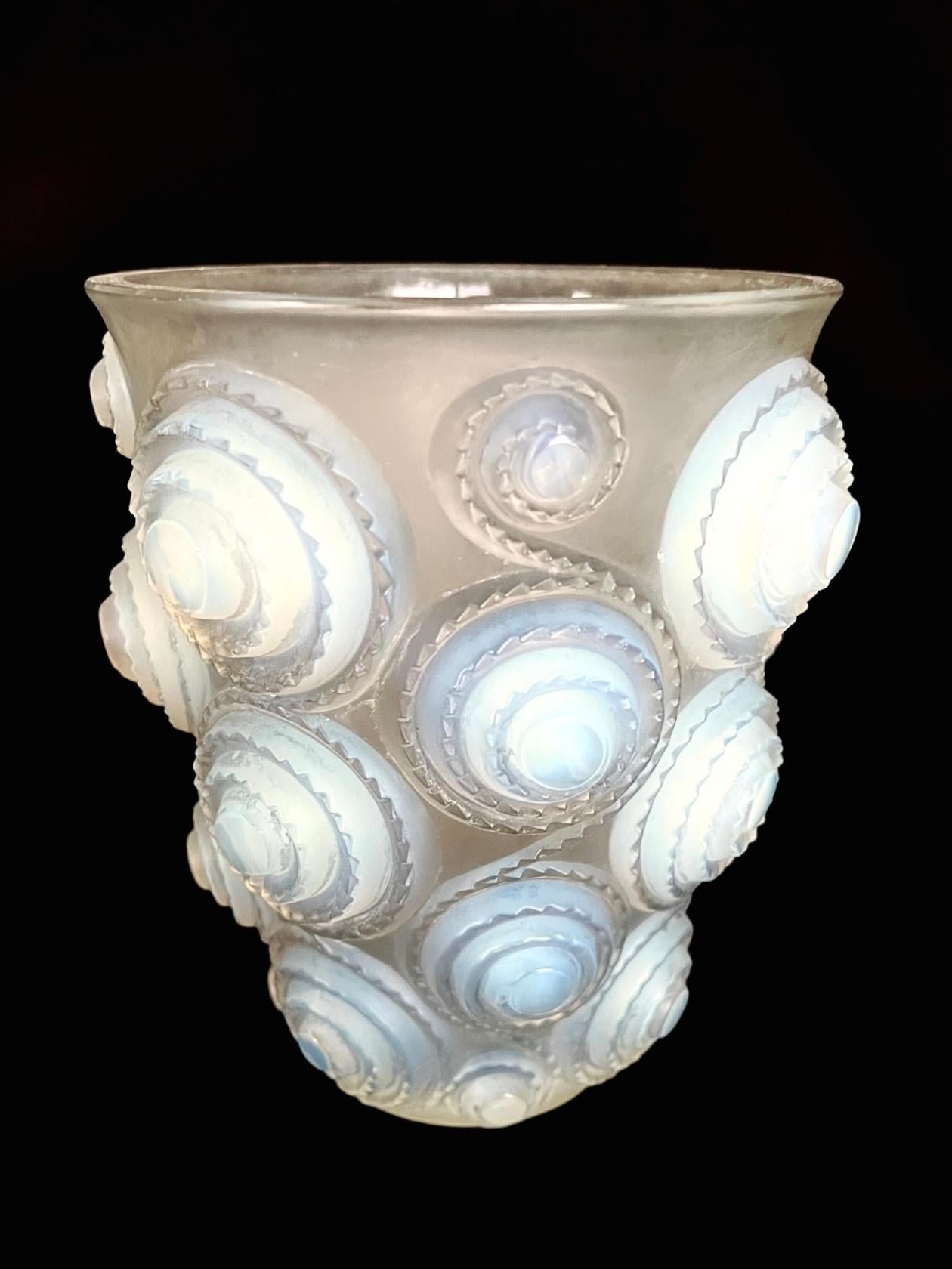 Auffällige Vase aus opalisierendem Glas im Art Déco-Stil mit einem Reliefmuster aus Spiralen und einem gezackten Rand.
Säuregeätzte Signatur 