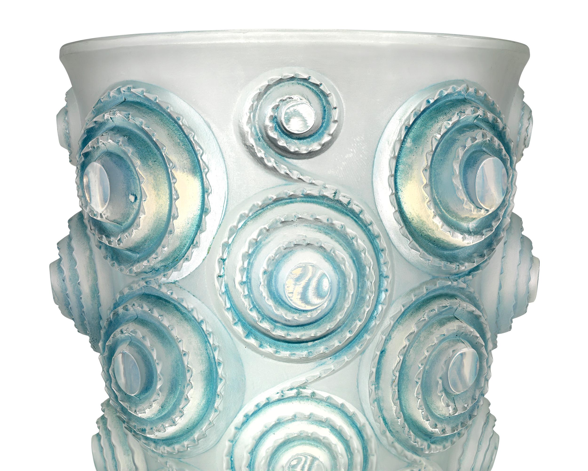 Spiraling circles are stacked atop each other to form this rare Lalique vase in the Spirales motif, first designed by René Lalique in 1930. Combining frosted and blue stained glass in high relief, this vase embodies the elegance and artistry of