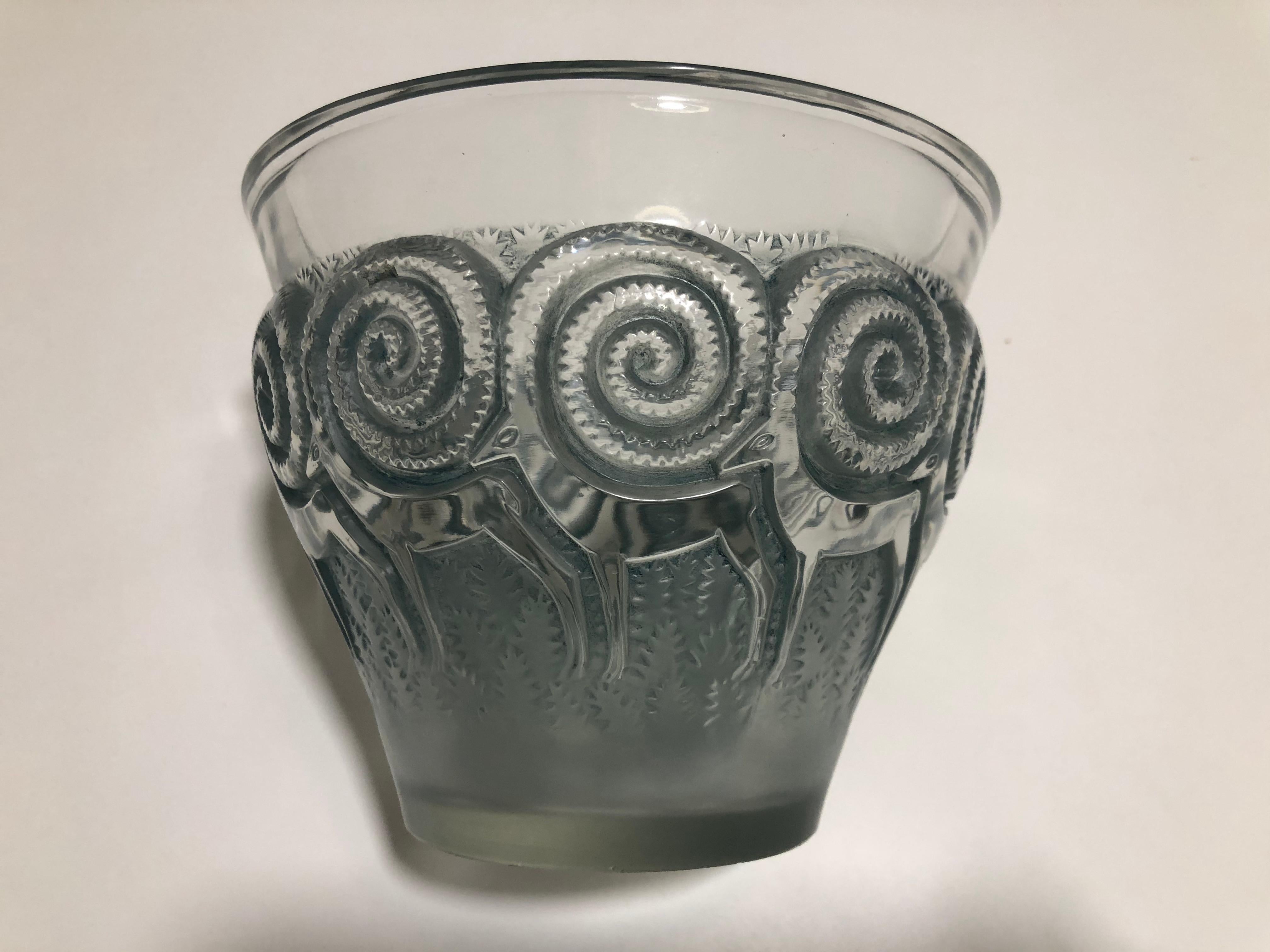 Rene Lalique vase Rennes: Glass with a design of frosted reindeer with large racks covering most of the outside Bibliography: Marcilhac model: 10-875 model created in 1933
Signed etched R Lalique, France
Pressed molded glass highlighted with grey