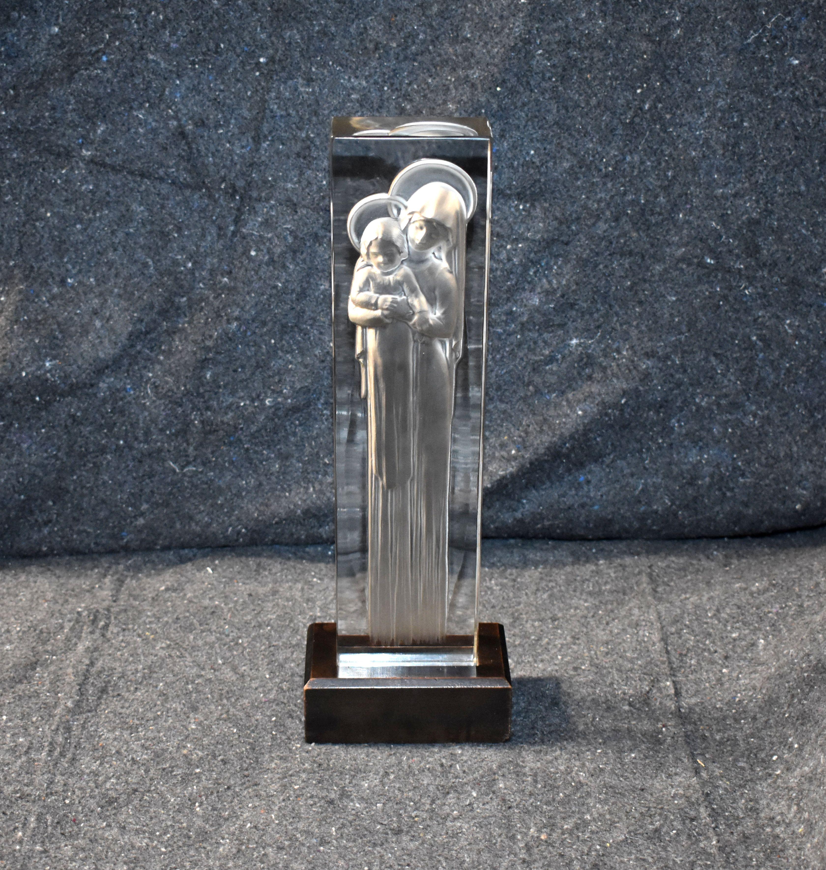 René Lalique statue Madonna and Child rectangular plinth form clear glass with frosted depiction of the Virgin and Baby Jesus on wooden base. Signed.

Dimension of sculpture without base:
H 13.25 inches W 3.40 inches D 2 inches.