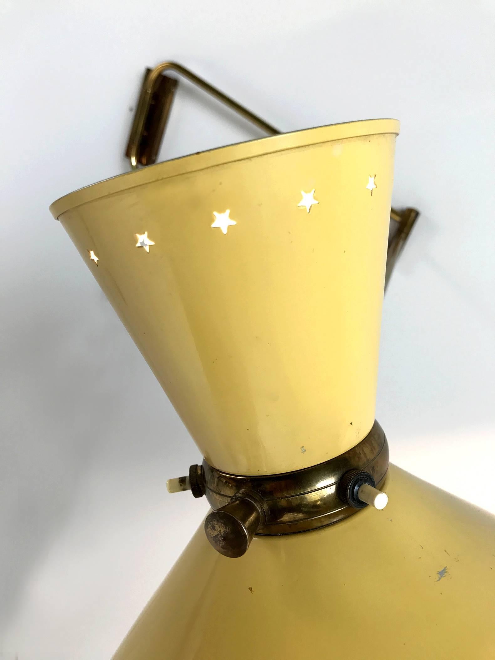 Double arm wall lamp in gilded brass and double lacquered yellow lacquered diabolo by René Mathieu for Maison Lunel, France 1950.
Rotatable, the double reflector is perforated with stars. Ideal in a reading corner, above a sofa or on a worktop.
 
