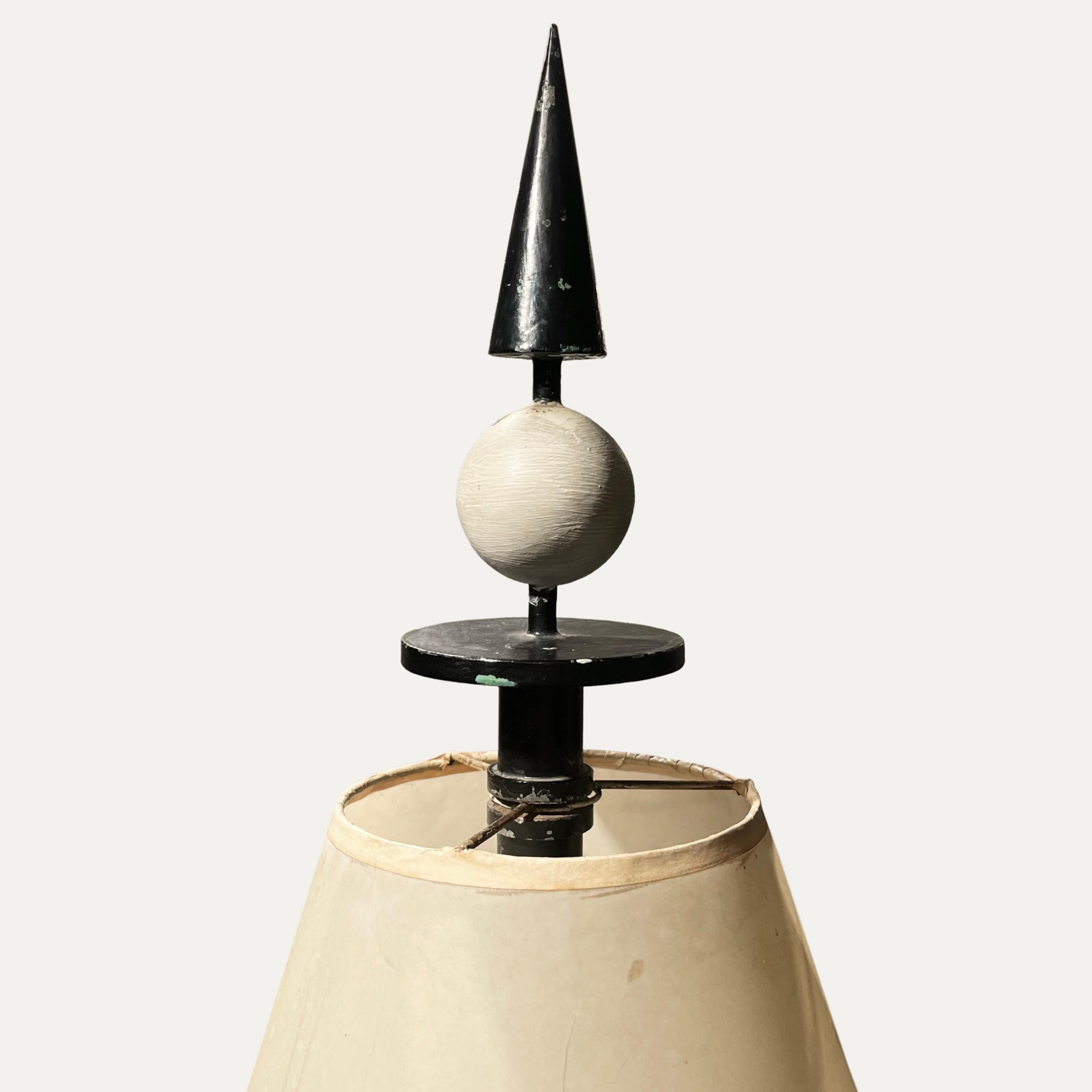 Rare lampadaire en fer laqué noir et blanc de René Prou, décoré de volutes et d'une sphère et d'un cône à l'extrémité de la tige. Il a conservé son abat-jour d'origine.

Provenance : Conçu pour un appartement parisien à Neuilly-sur-Seine, l'ensemble