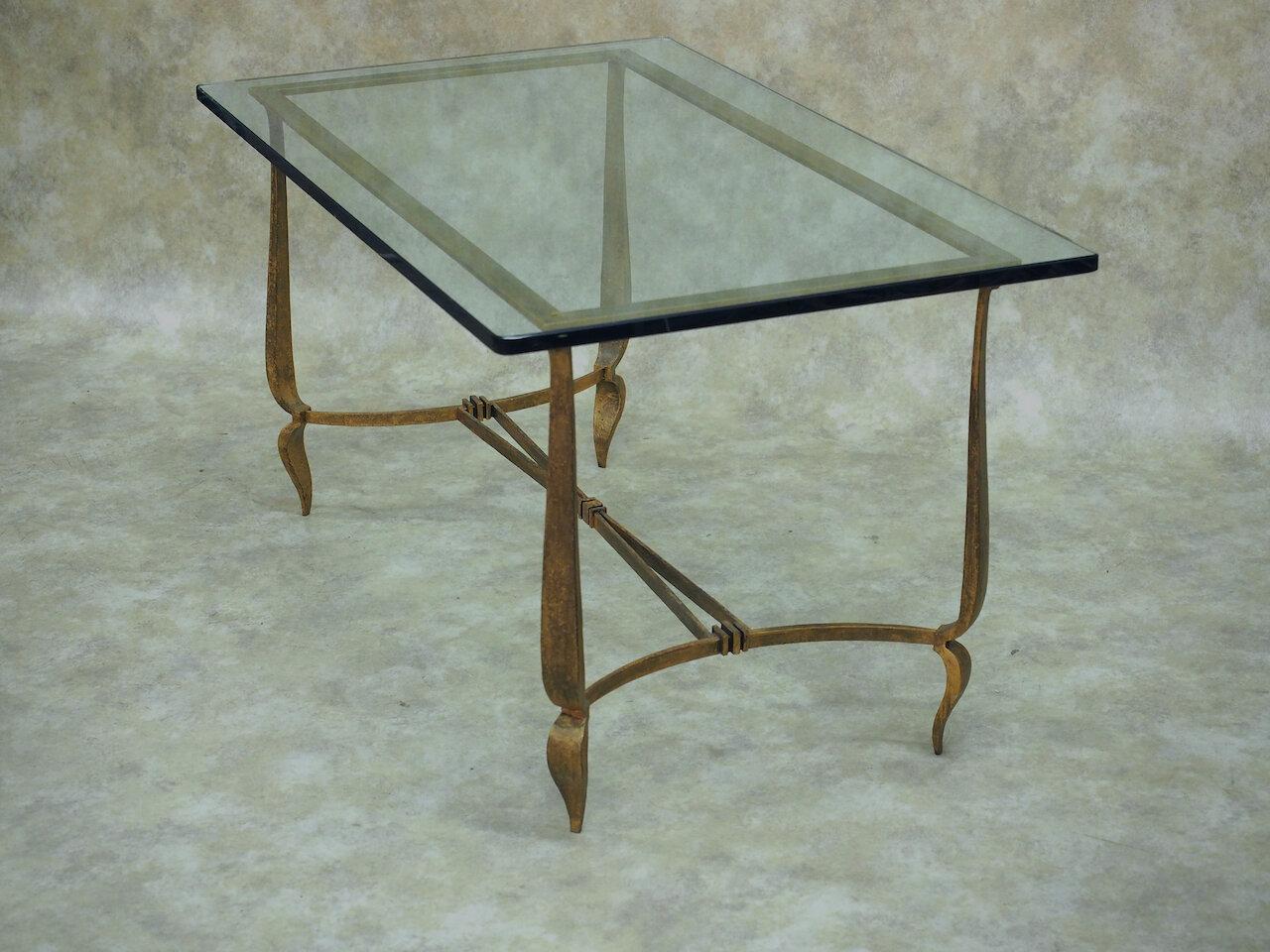 French Art Deco coffee table in gilt hand forged iron, by Rene Prou, circa 1930. 44” long x 26” wide x 23” high with glass. Frame: 41.5” long x 21” wide.

Rene Prou

(1889-1948)

A decorator as well as furniture designer, Rene Prou was born in