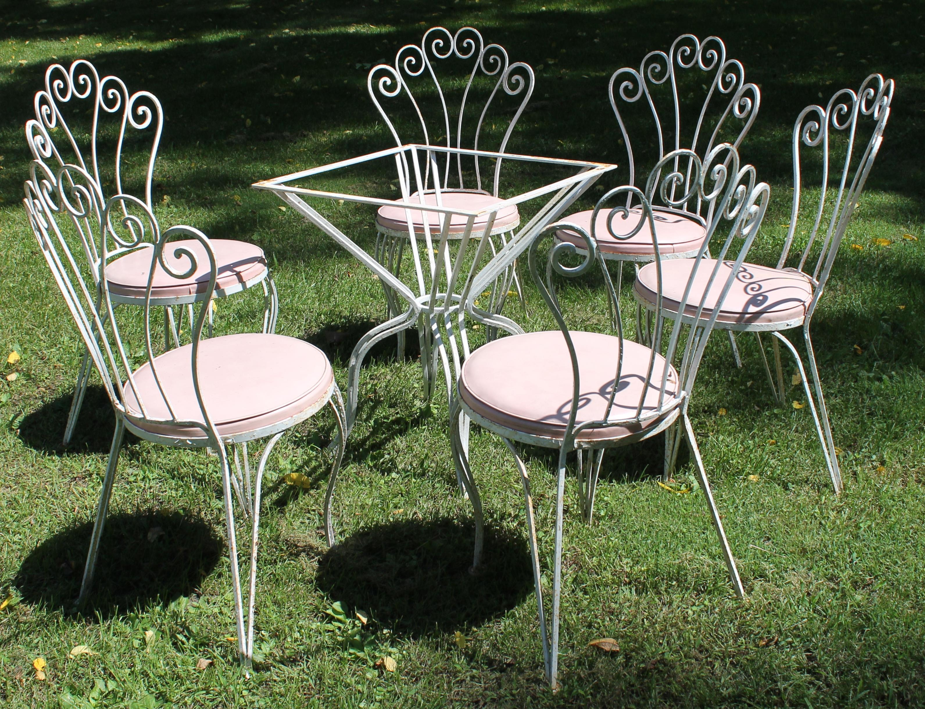 Six chairs with pink 'Naugahyde' covered round seats, with a matching table. Tabletop measures 24