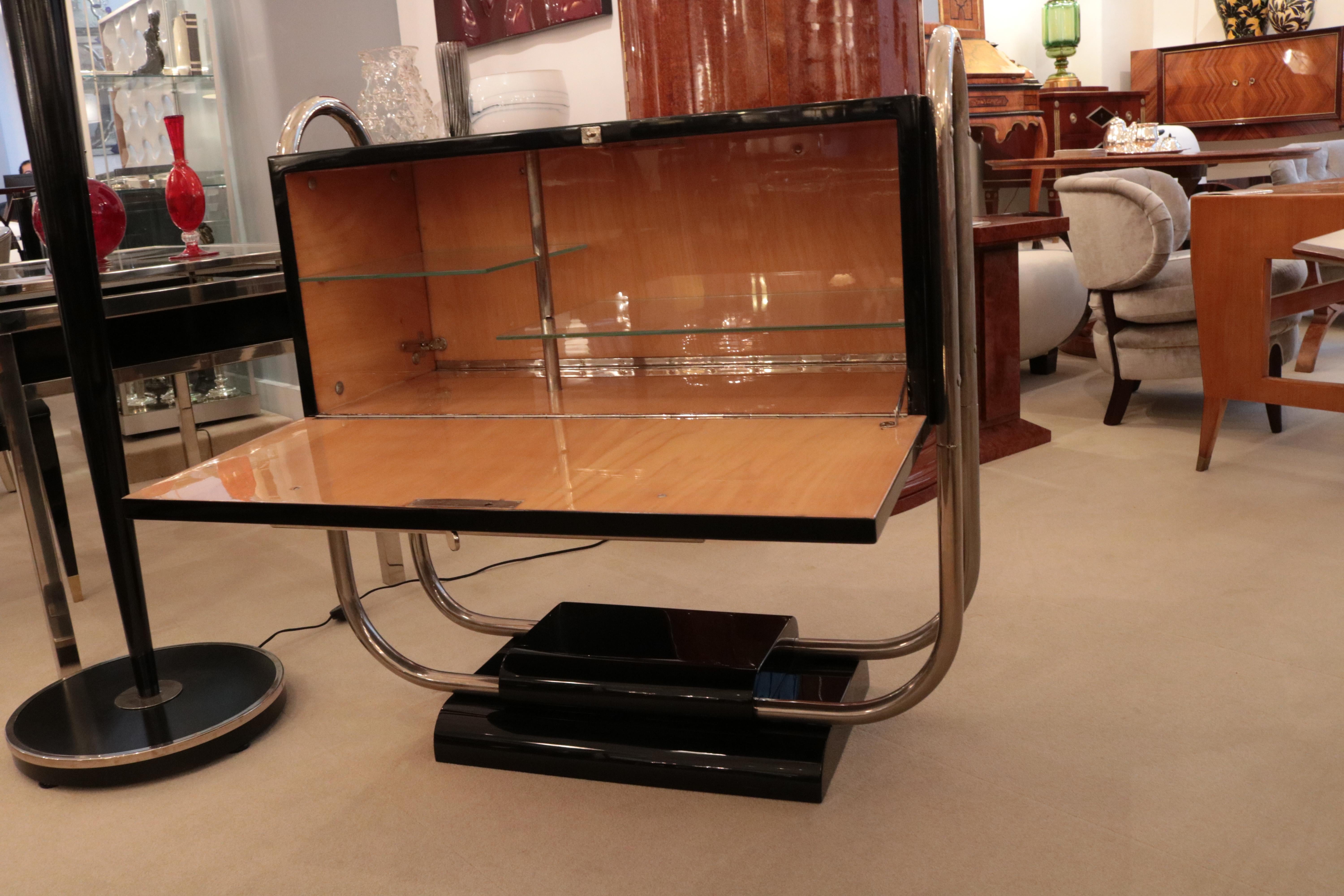 An Art Deco free standing bar cabinet designed by Reneé Herbst. 
Black lacquer with polished nickel details. 
Doors on both sides open to a sycamore lined interior with glass shelves.