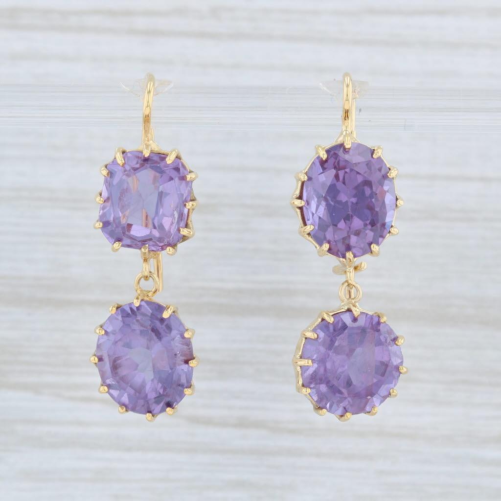 These earrings are a Renee Lewis design with a retail of $8200. 

Gem: Synthetic Sapphires - 15.6 Total Carats, Purple Color
Oval Brilliant - 9.8 x 8.5 mm
Corner Cut Squares - 8.3 x 8.3 mm
Round Brilliant - 9 x 9.1 mm
Oval Brilliant - 9.1 x 8.4 mm