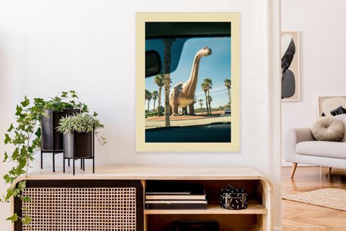 This bright yellow, blue, and green dinosaur photograph is a limited edition print by Canadian artist Renée Rodenkirchen. Featuring a neutral border, this representational photo from the artist's personal collection is part of a series chronicling