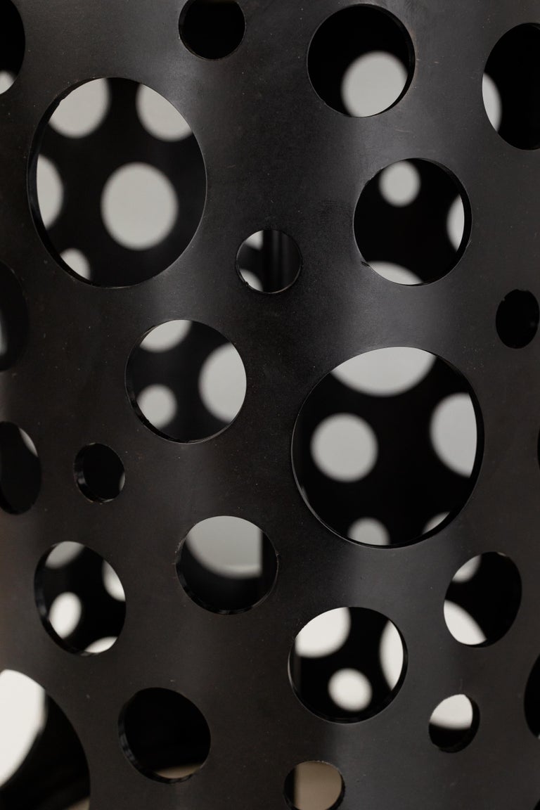 Punched steel, random circles. Perforated circular cut outs on cylindrical body table lamp. 

Bulb 1x medium base 75 watt incandescent. 

Handcrafted in Italy. Sold exclusively at Brendan Bass.

Shade: 19
