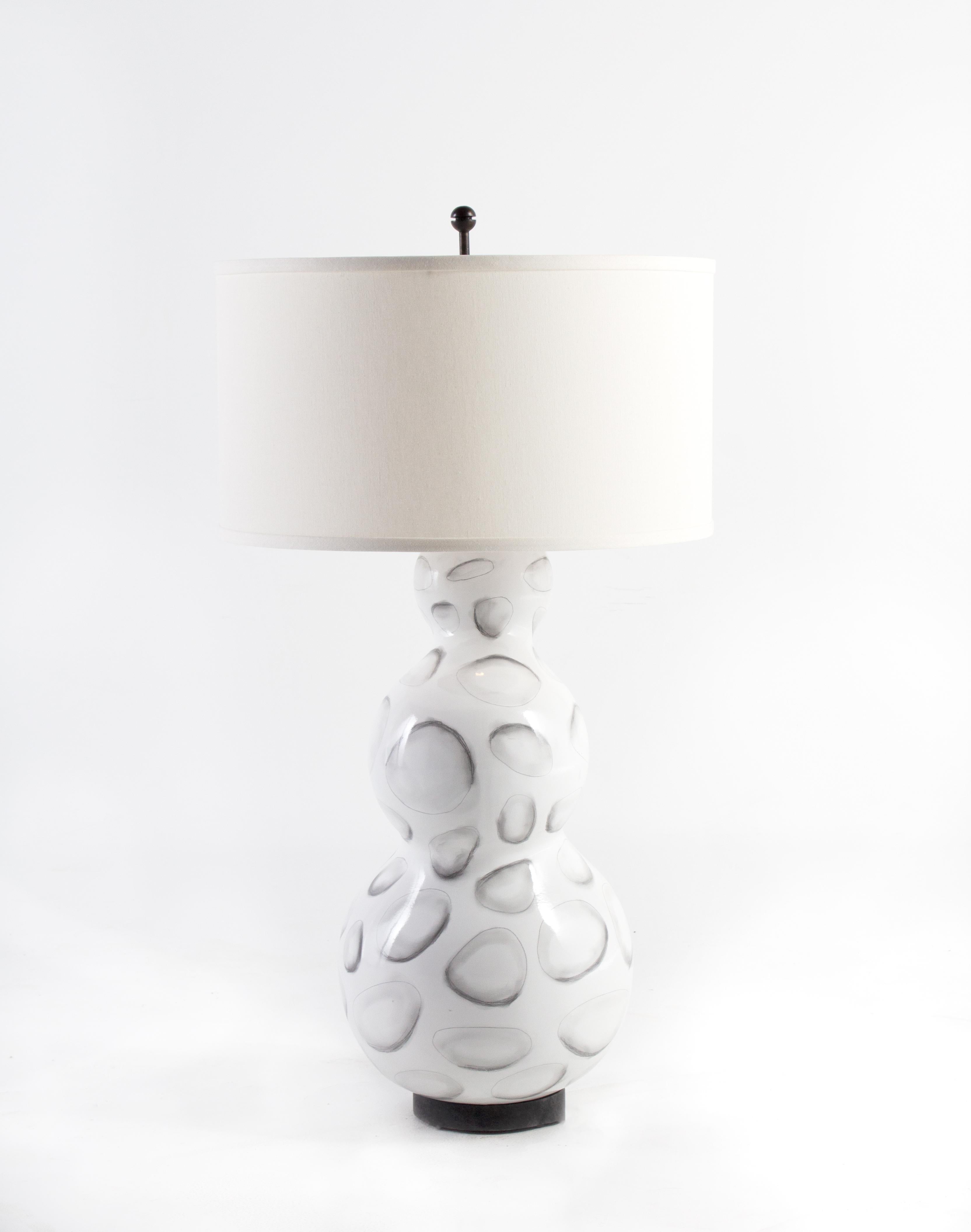Lamp, gloss white glazed ceramic with stylized shell design

 Off-white linen shade. 32