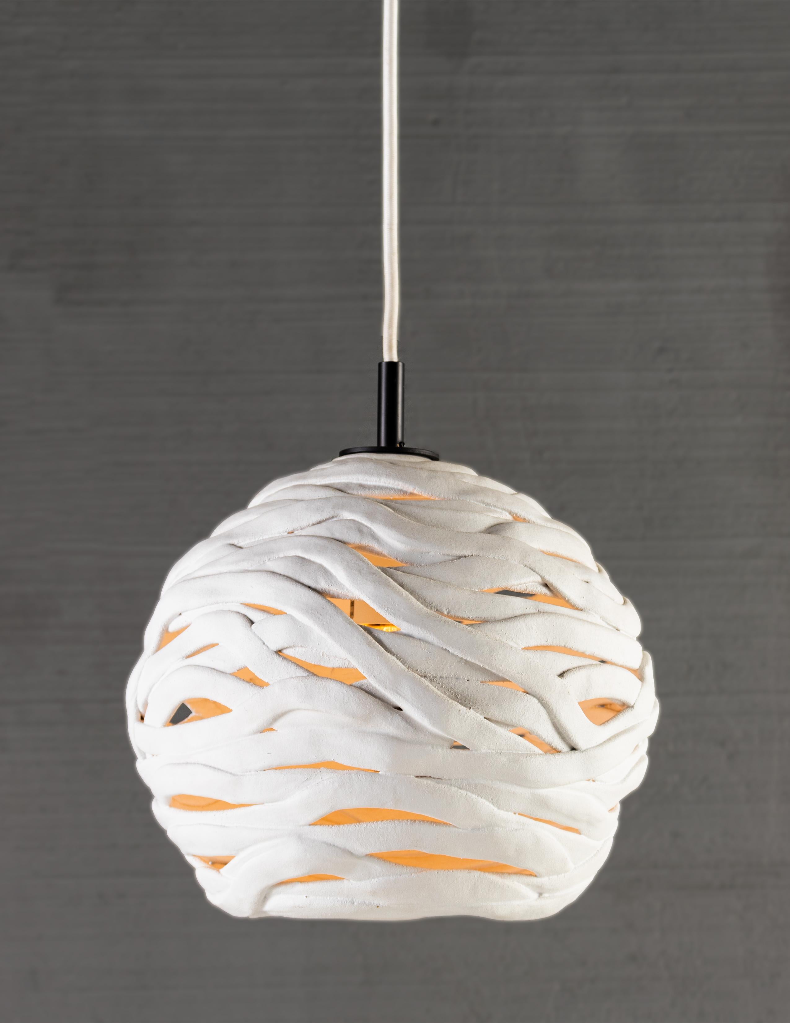 RENG, wrap, hand formed ceramic chandelier light.

The Wrap pendant is formed of individual hand formed strips of terra-cotta molded and set in place by hand. Wrap is more an artistic expression than a light fixture, a story of craft and patience in