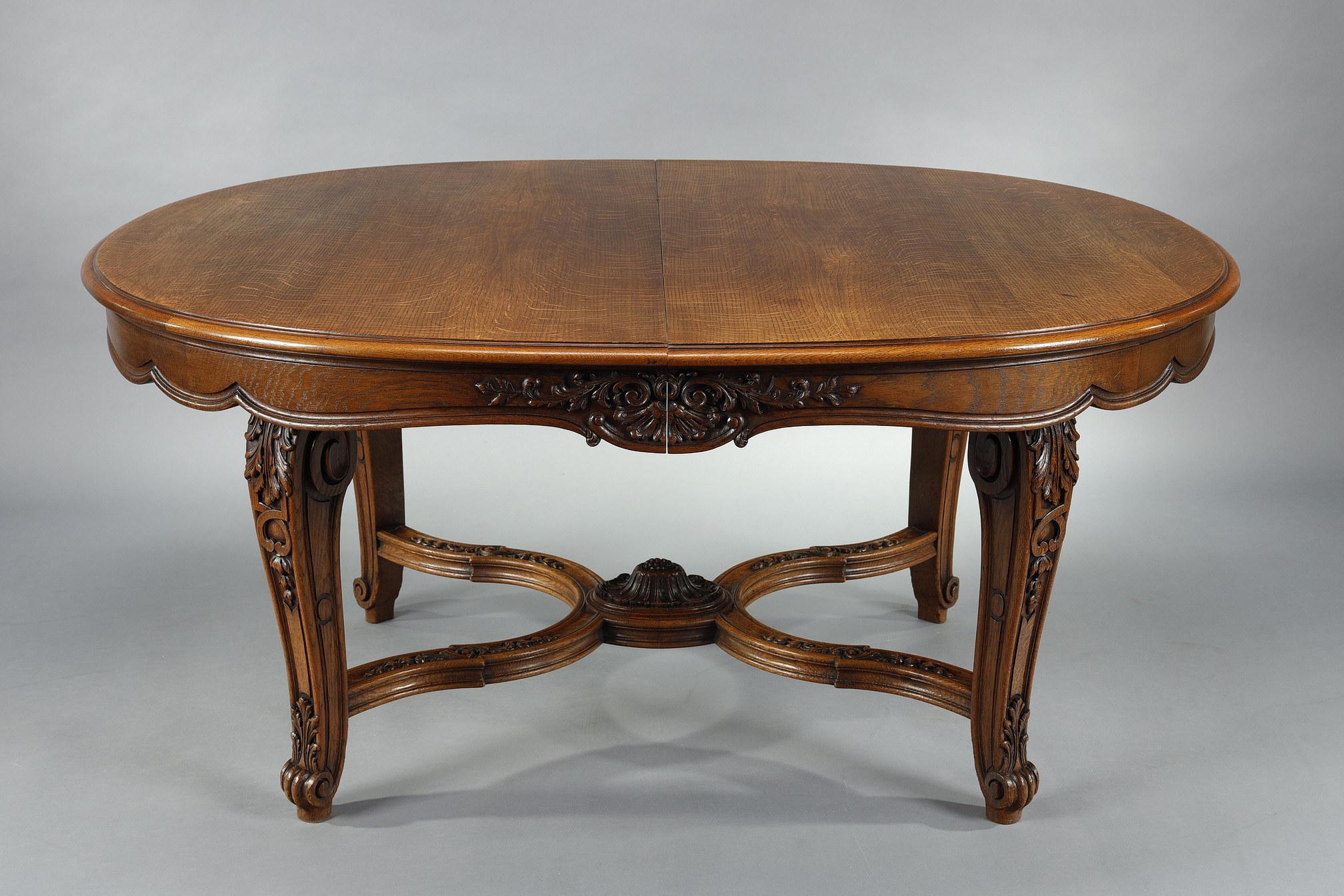 Dieser schöne Tisch, seine 9 Stühle und 2 Sessel sind Teil einer seltenen und bedeutenden Essgarnitur im Regency-Stil aus geformter und geschnitzter Eiche. Der Tisch enthält 4 Verlängerungen von je 50 cm, was eine Gesamtlänge von 260 cm ergibt (mit