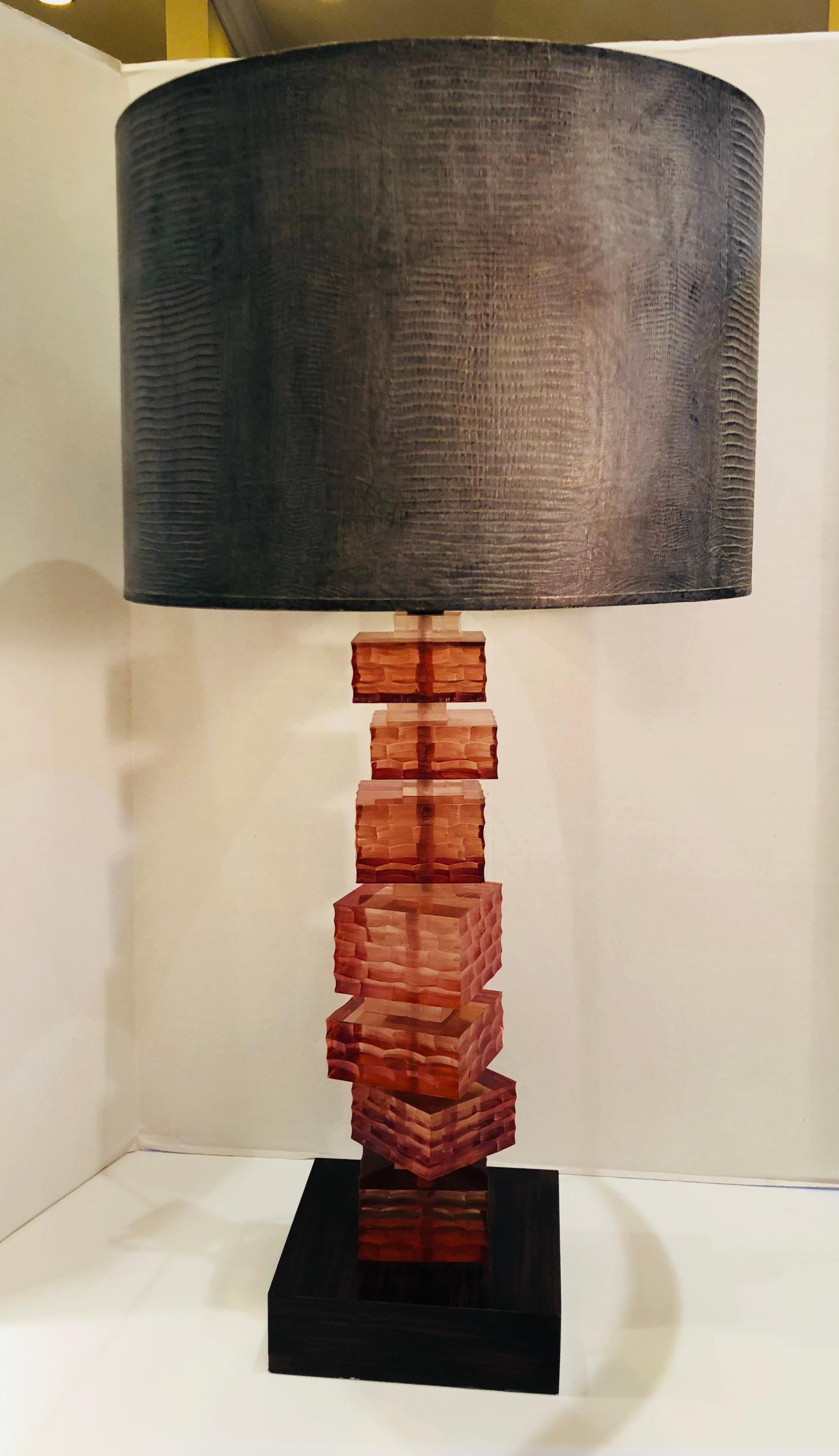 Striking acrylic lamp was pictured in architectural digest magazine and is a work of art!

Chic modernist table lamp features a stack of 7 honeycomb textured Lucite blocks of varying sizes in a cognac amber color, alternating with 7 smaller Lucite