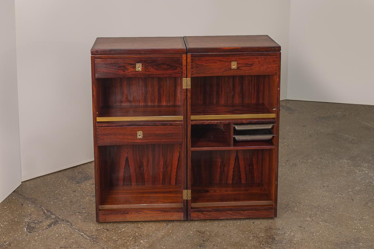 Phenomenal folding dry bar by Reno Wahl Iversen for Dyrlund. A remarkable design, that opens up to reveal drawers, ice trays, and beautiful brass hardware details within. The top unfolds on both sides offering a black, laminated surface for
