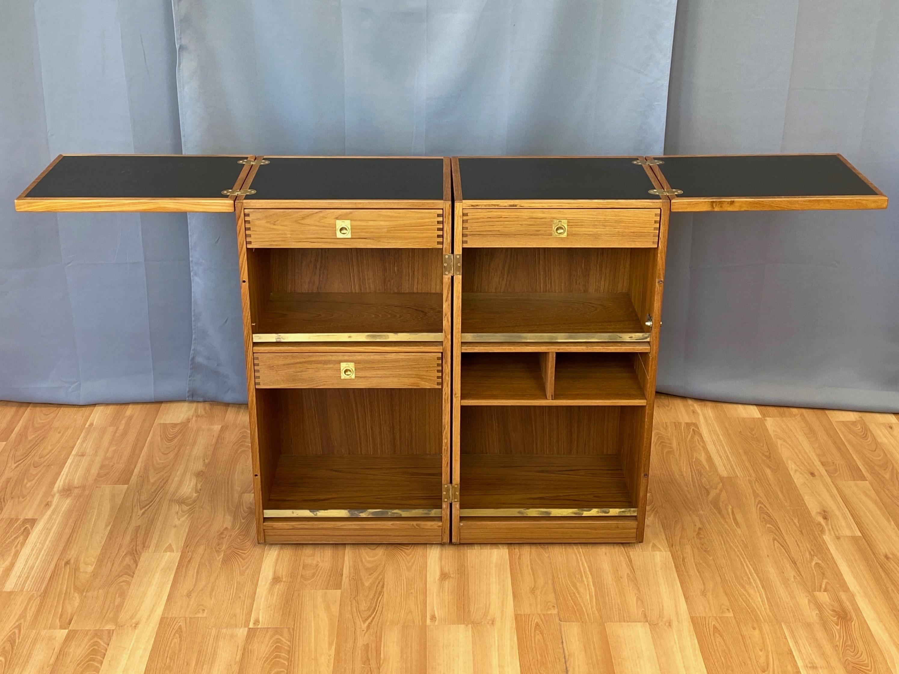 A fantastic 1960s Danish folding and convertible captain’s bar in bookmatched teak by Reno Wahl Iverson for Dyrlund.

Compact enclosed storage cabinet on casters transforms into a tidy dry bar with a spacious fold-out black laminate top supported by