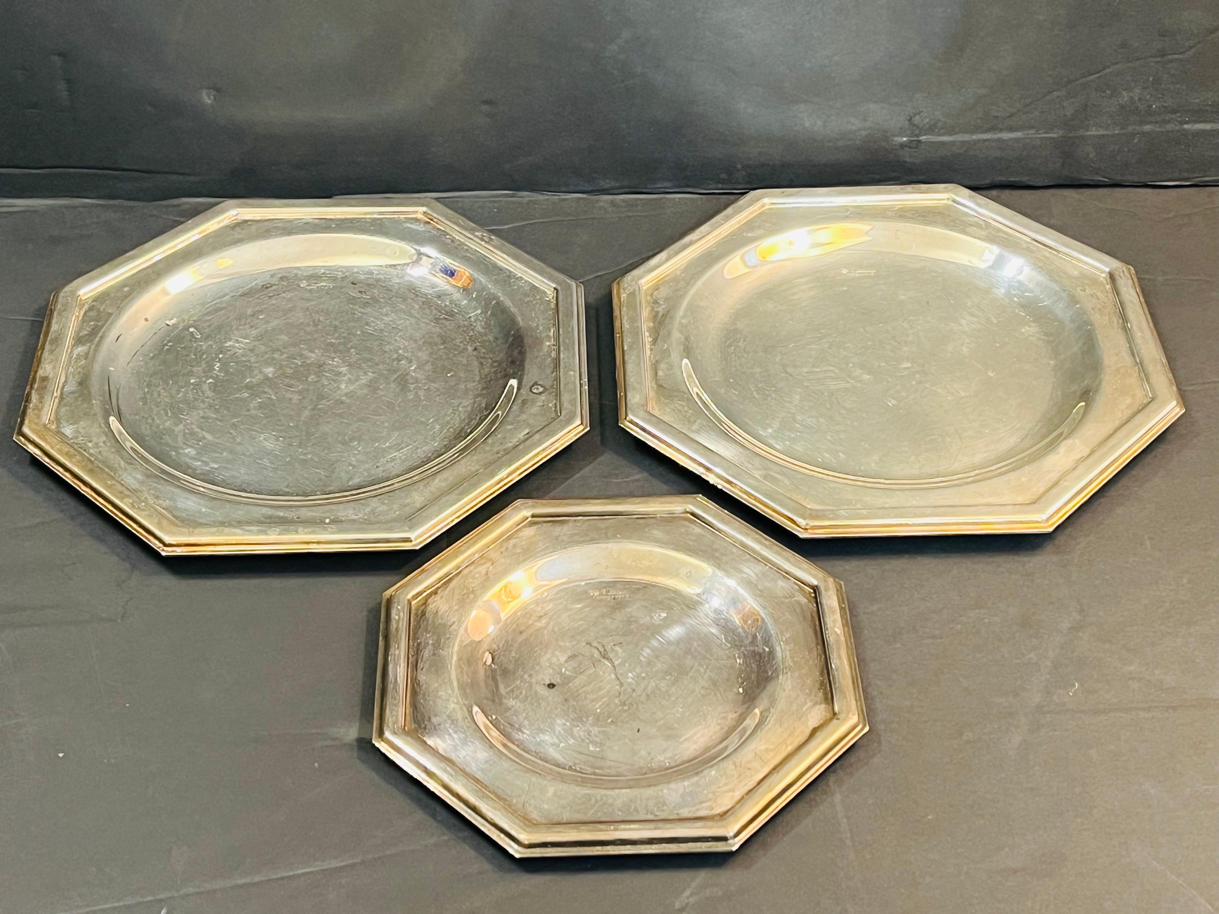 A set of three vintage, mid to late 20th century octagonal shaped platters in silver plate by Italian maker Cassetti. The Cassetti firm was founded in Italy in 1926 by Renzo Cassetti. The three plates have strong Art Deco style lines and all are of