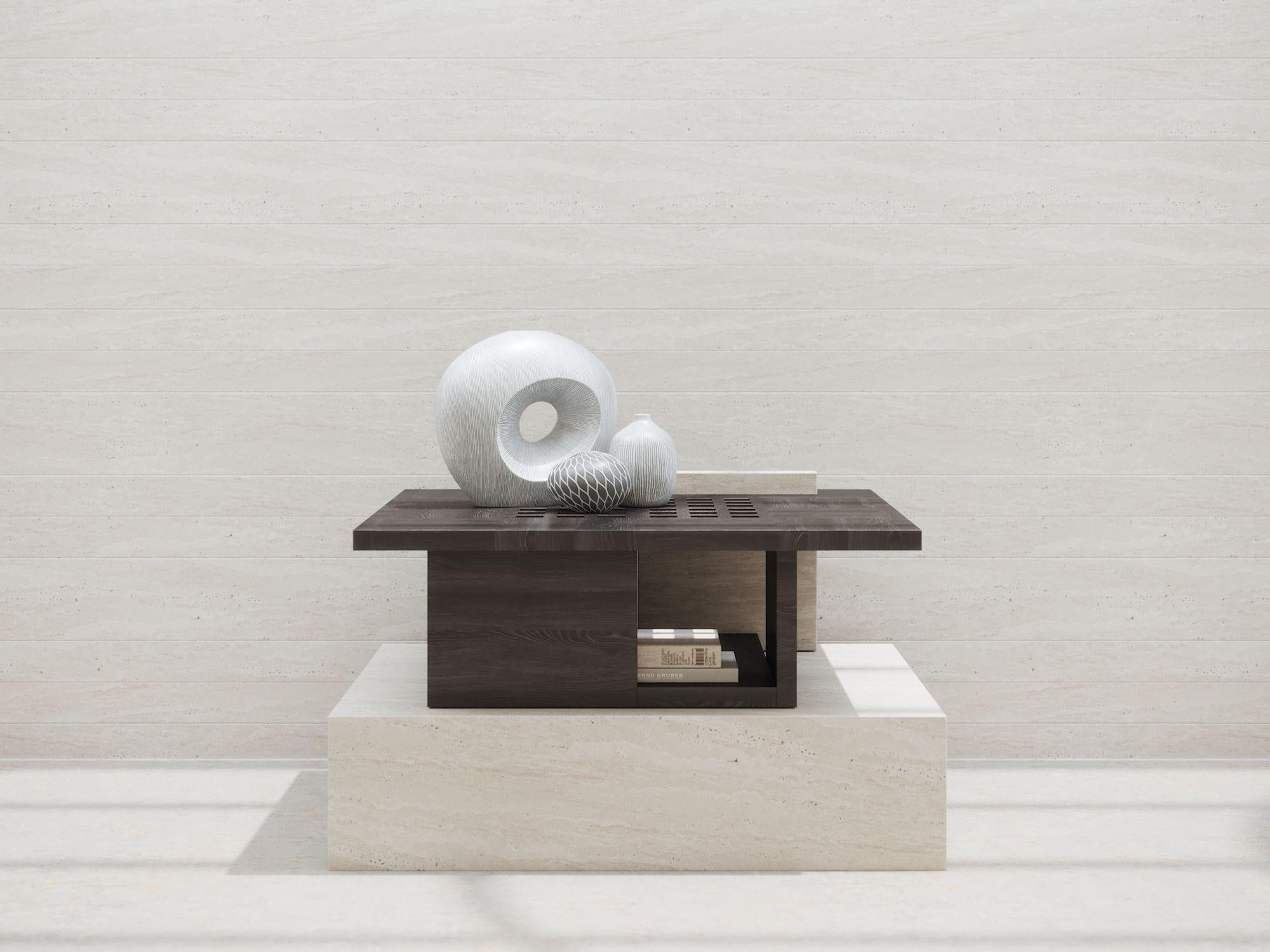 La table d'appoint Renzo, fabriquée en chêne noir et travertin blanc, est un mélange étonnant de design et de fonctionnalité. Le plateau présente des trous décoratifs traversants, permettant à la lumière naturelle d'atteindre le niveau inférieur,