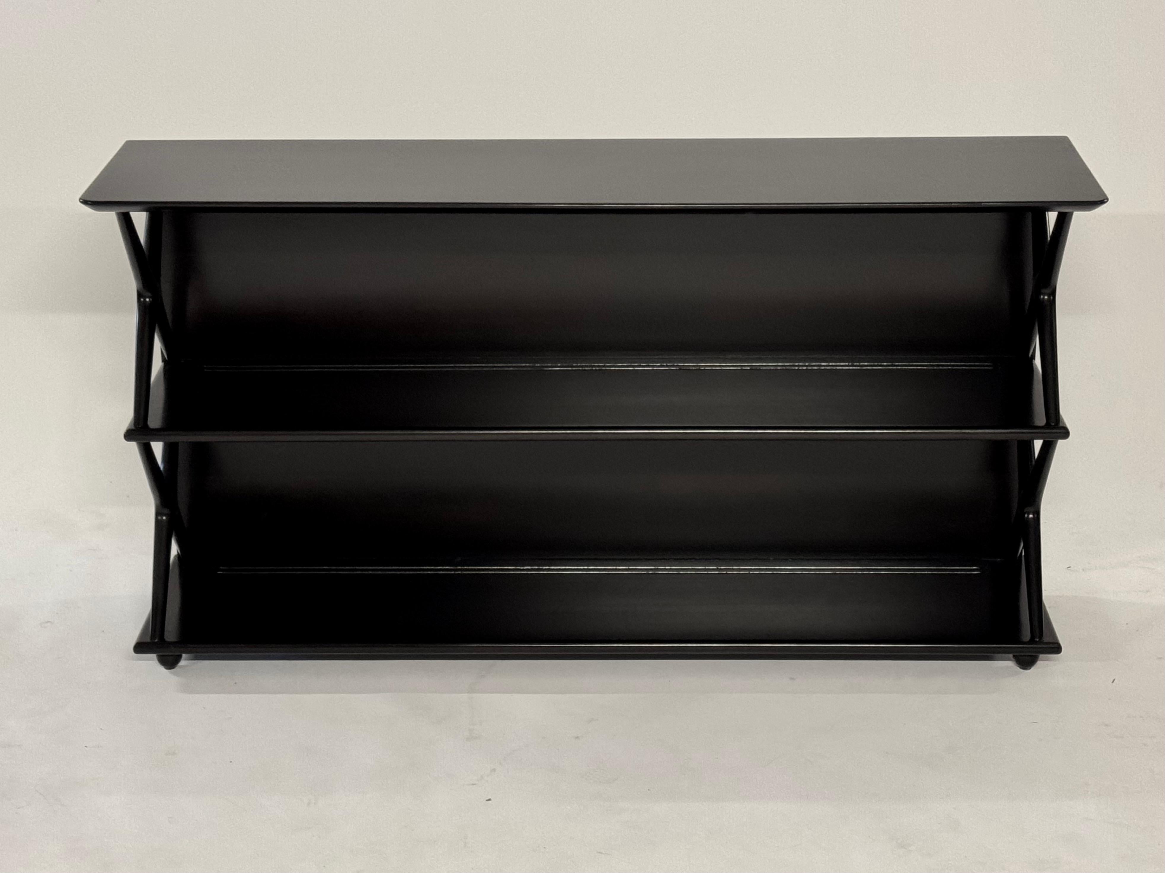 1950s Mid-Century Modern Renzo Rutili for Johnson Furniture Co. low form shelving unit or bookcase with stylized X form ends on round bun feet. 

In the style of Edward Wormley for Dunbar, Harvey Probber , Tommi Parzinger and Paul McCobb. 