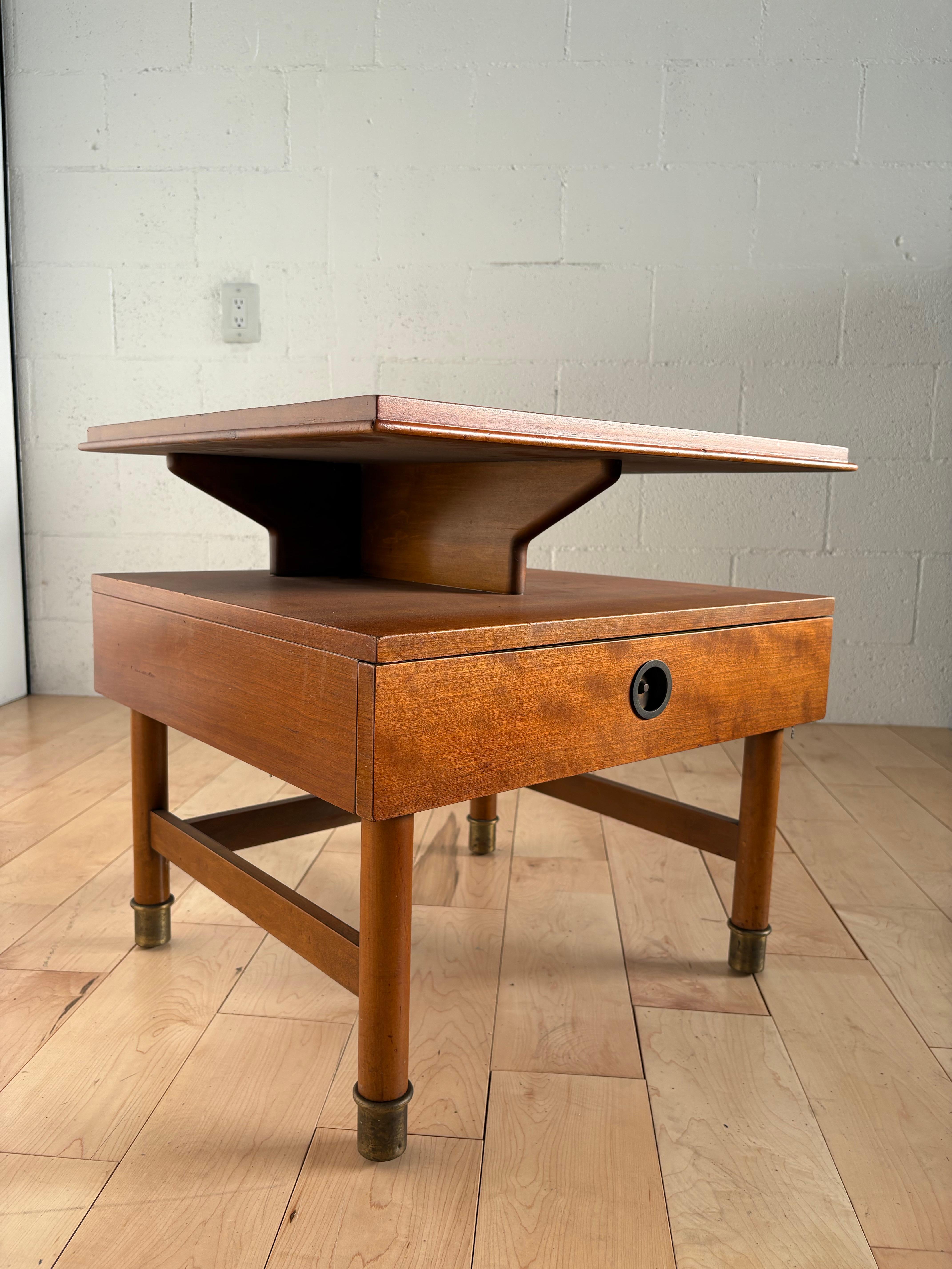 Comodino raffinato e architettonicamente composto della metà del secolo scorso, attribuito a Renzo Rutili per Johnson Furniture Company, USA, circa 1950. Realizzato in una calda miscela di mogano e acero, questo pezzo bilancia le linee pulite con la