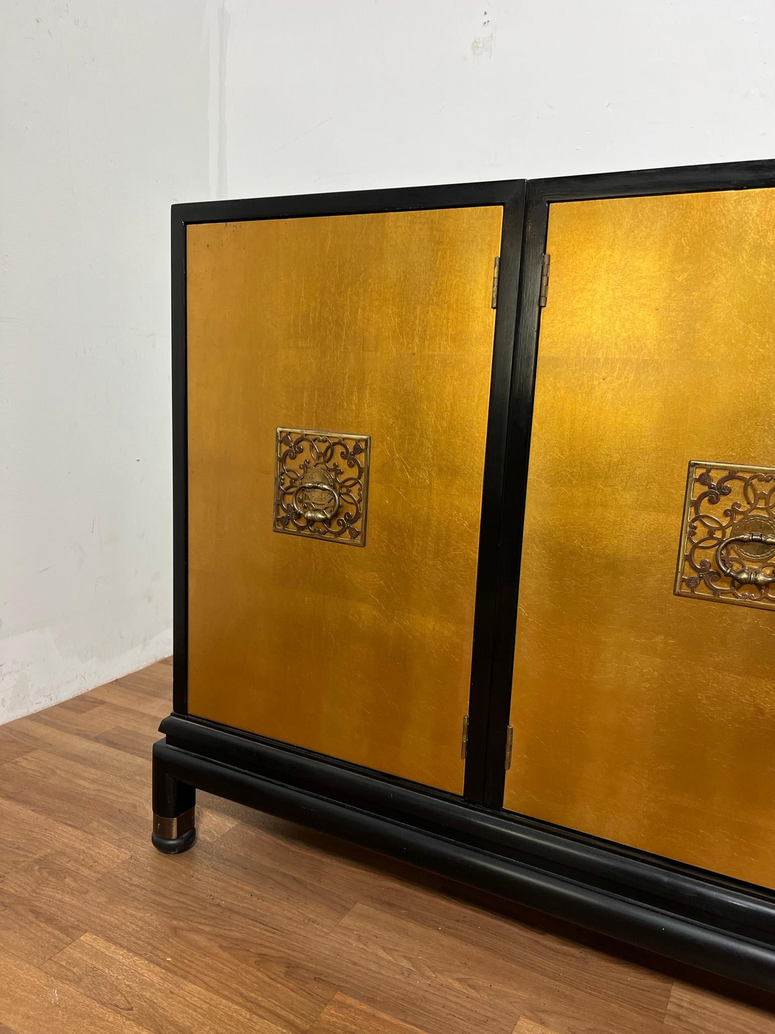 Renzo Rutili for Johnson Furniture Company credenza consisting of four chests with gold leaf door fronts and lacquered cases, resting on a platform bench. The smaller chests on either end each feature an adjustable shelf. One of the larger chests