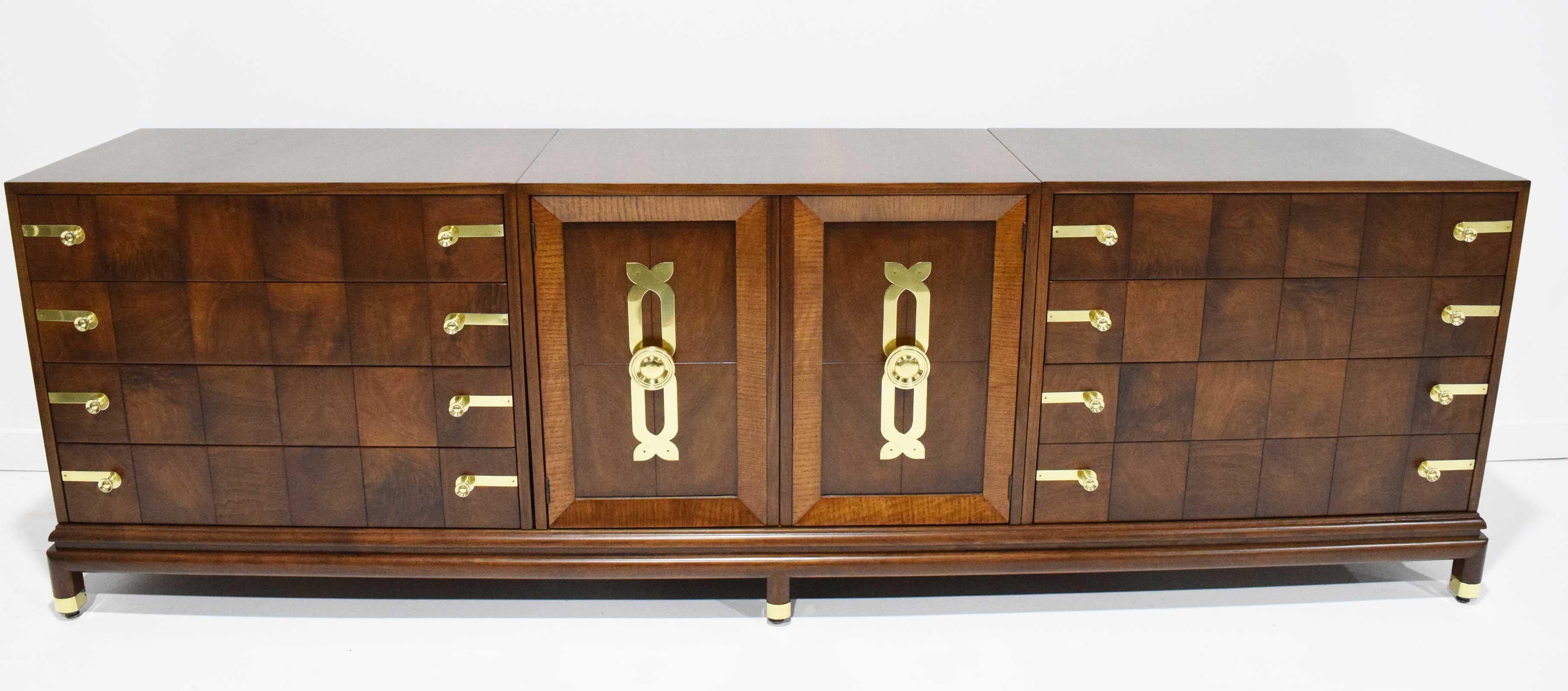 Beautiful sideboard/credenza by Renzo Rutili for Johnson Furniture Company. Executed in walnut and brass, comprised of three bays that sit on a singular base.

Lorenzo (Renzo) R. Rutili 1901-1966

Lorenzo (Renzo) Rutili was born in Donora,