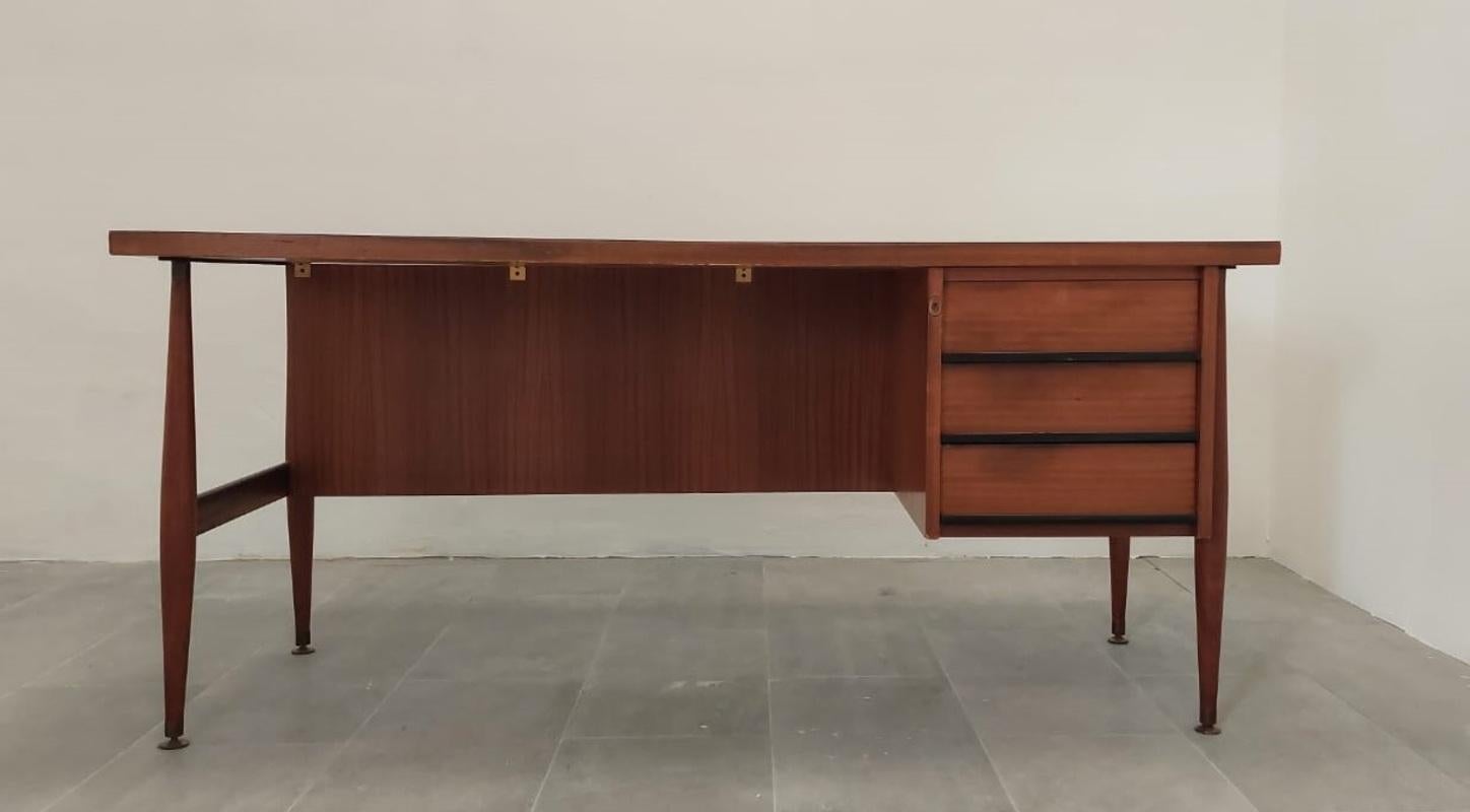 Office desk or writing desk by Renzo Schirolli with drawers realized in wood, with laminate on top in a dark green shade, details in brass and metal (key, and feet), Italian manufacture from the 1960s.
 