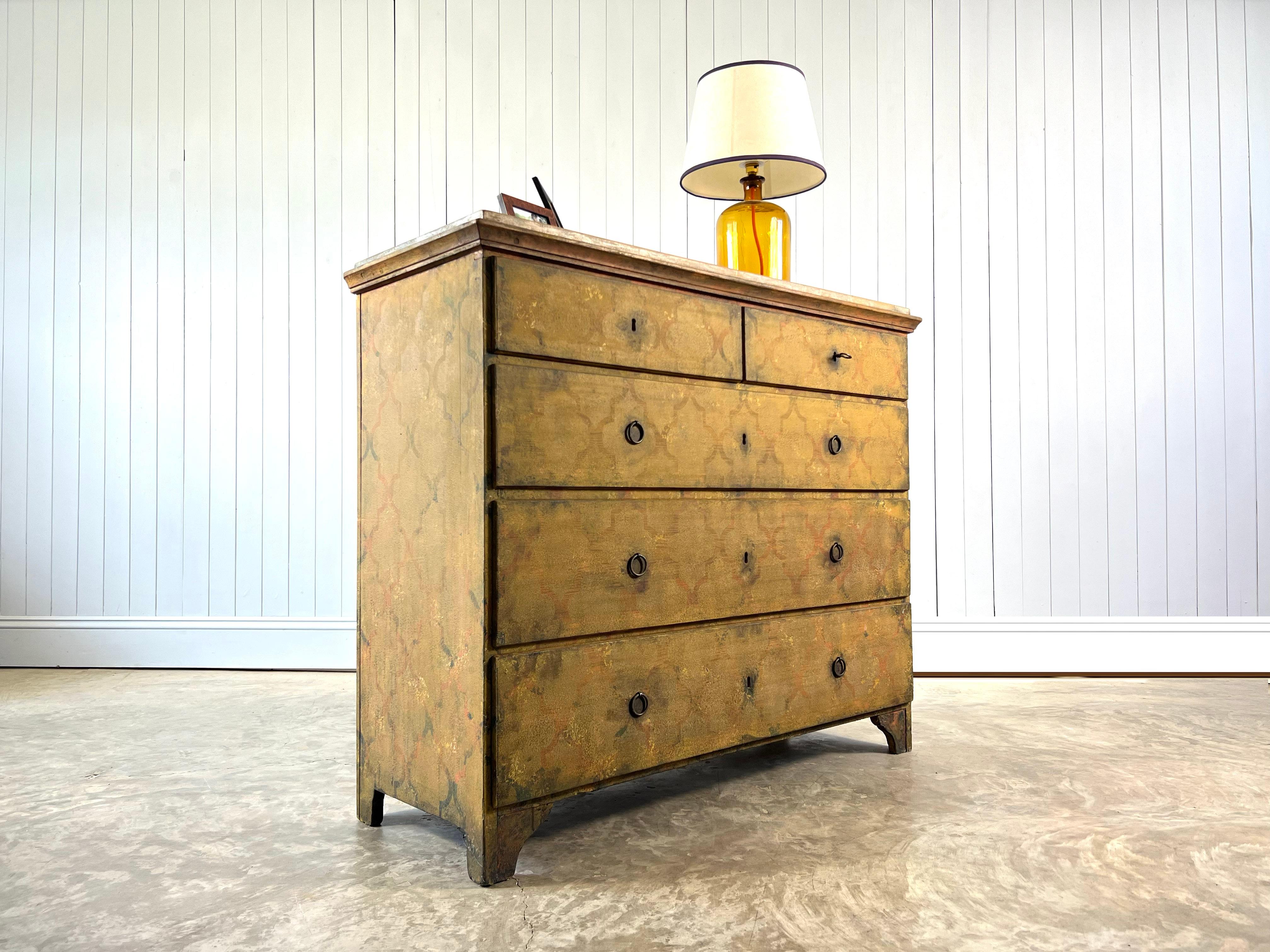 This antique chest of drawers is late 19th Century.

We have newly re-painted it with a geometric design working with the original colours.

The top would have had a faux marble design painted on it which is all now lovely and faded.

Some